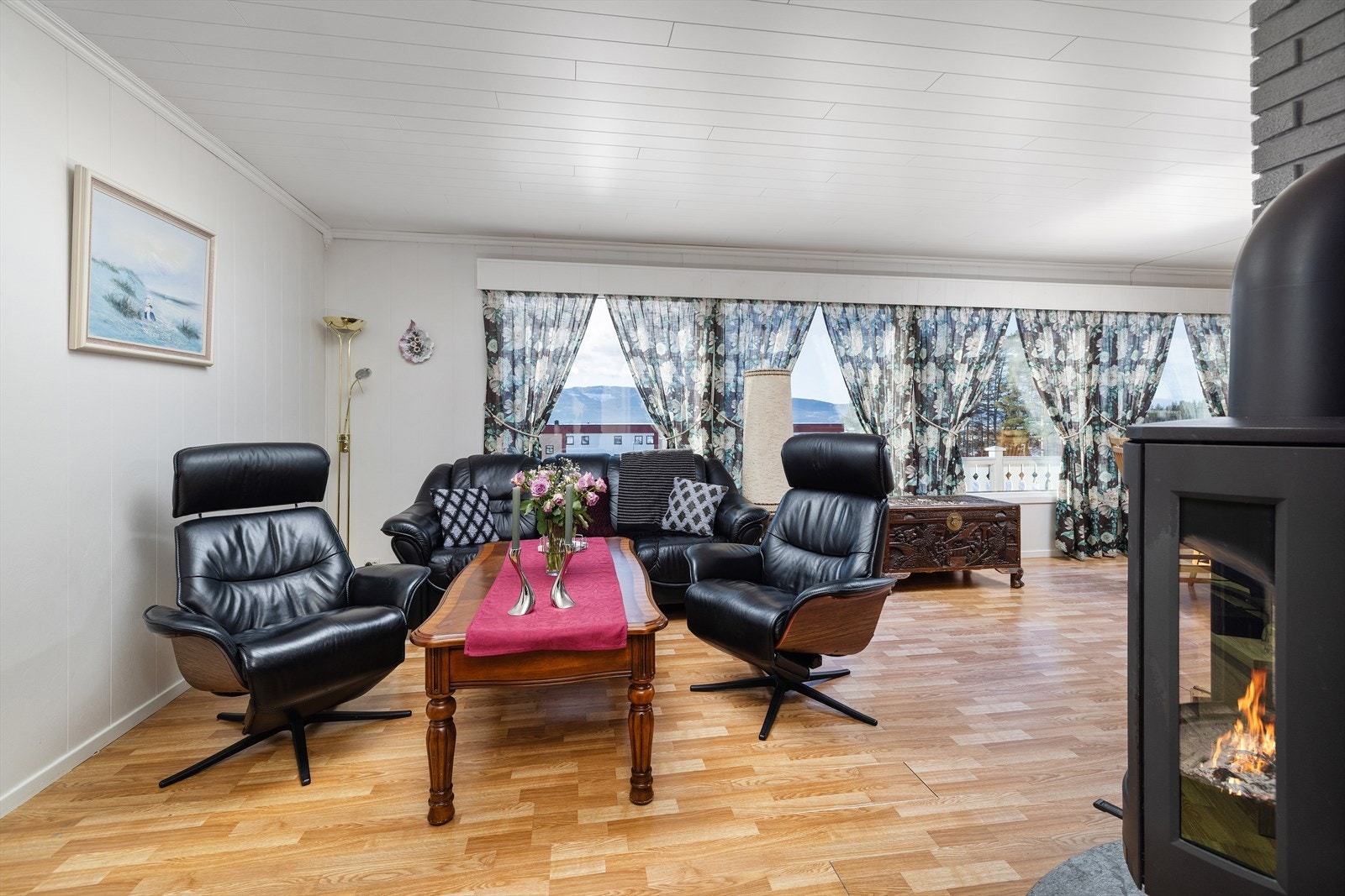 Det er lyse malte overflater på vegger og tak. Gulvet er av laminat. Galleribilde