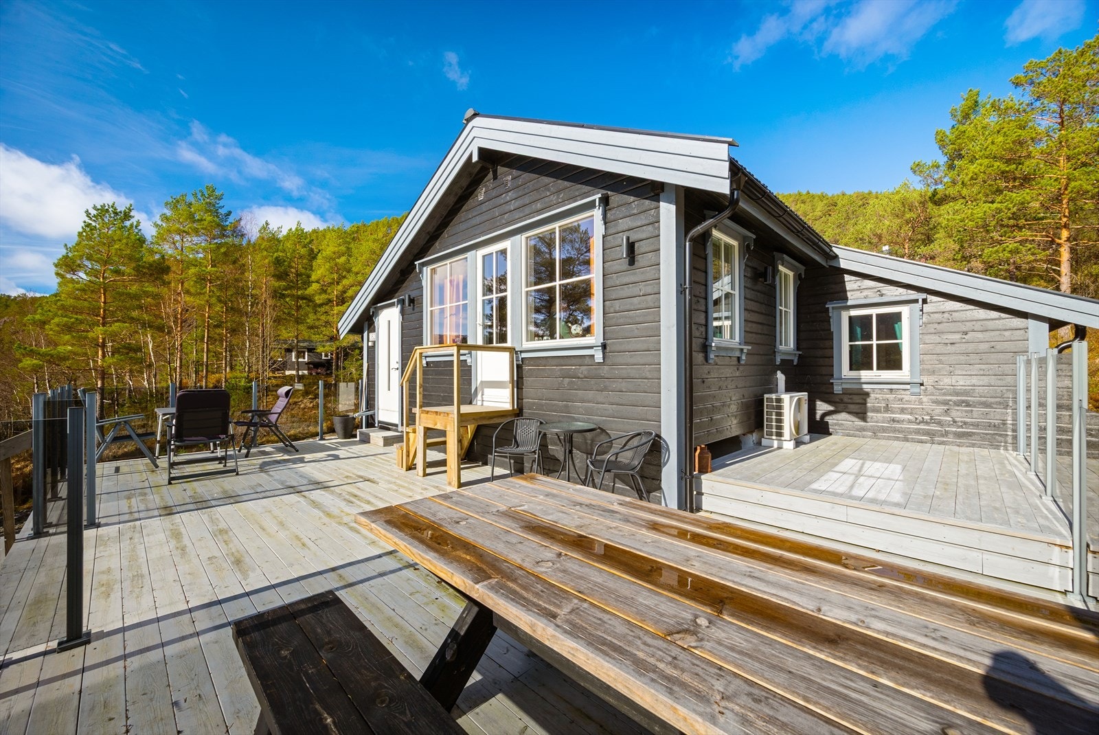 Fra hytten er det utgang til solrik terrasse med gjerde rundt og med Jacuzzi Galleribilde