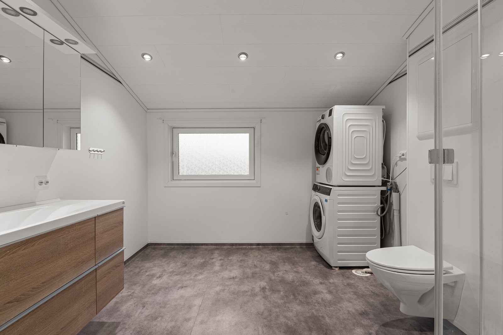 Badet i 2. etasje har innredning med nedfelt servant, veggmontert toalett, dusjkabinett og opplegg for vaskemaskin. Gulvet har vinylbelegg med elektriske varmekabler. Galleribilde