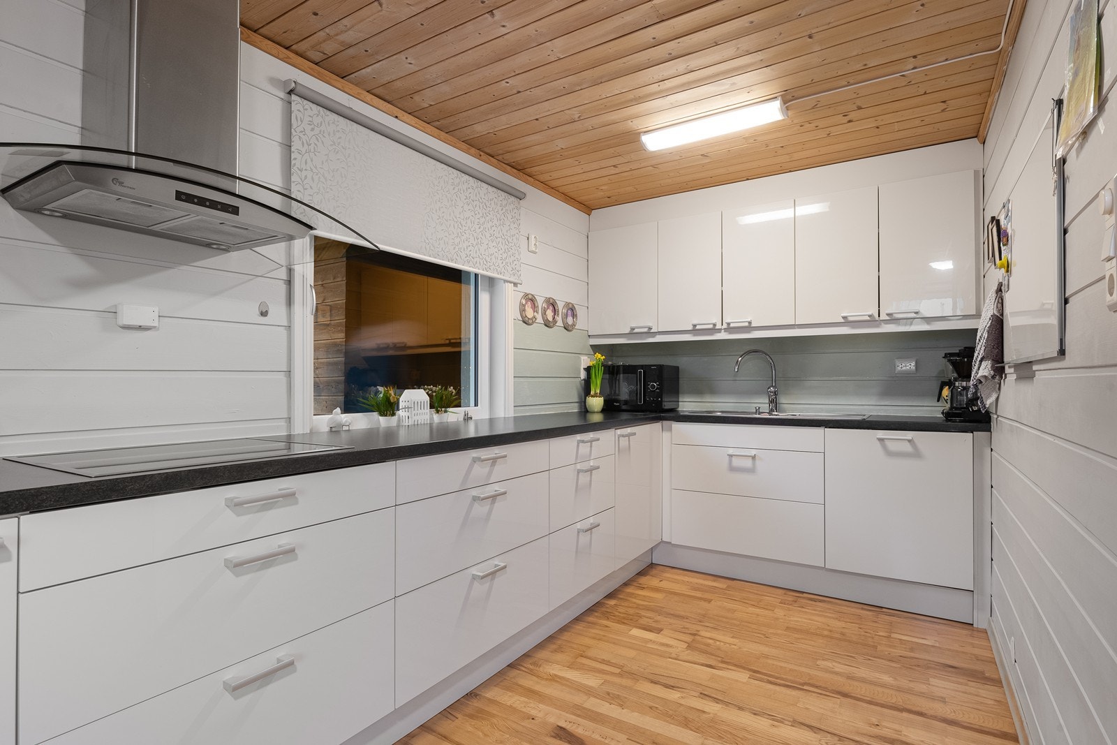 Kjøkkenet i underetasjen har moderne innredning med glatte fronter og laminatbenk. Det er utstyrt med kjøl/fryseskap, oppvaskmaskin, platetopp og stekeovn - praktisk og funksjonelt (etasjen er ikke godkjent for varig opphold). Galleribilde