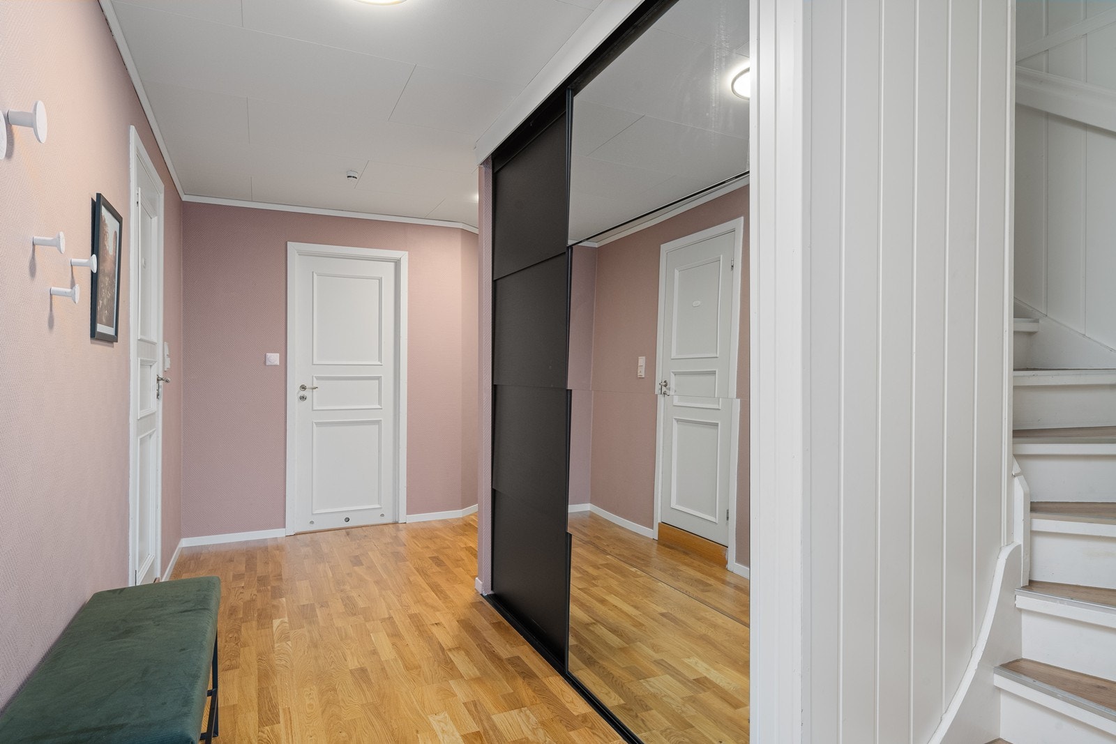 Lys og romslig entré i hovedetasjen med praktisk skyvedørsgarderobe som gir god oppbevaringsplass og holder rommet ryddig. Galleribilde