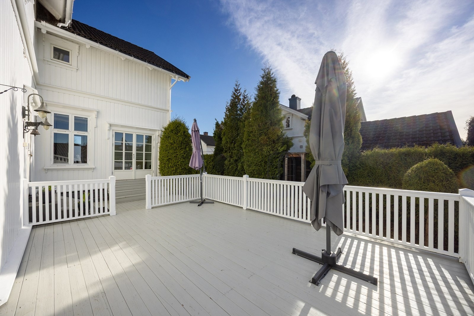 Ved inngangen har boligen en veranda og en delvis overbygd terrasse, og sammen skaper de et stort uterom med ulike soner for familien. Galleribilde