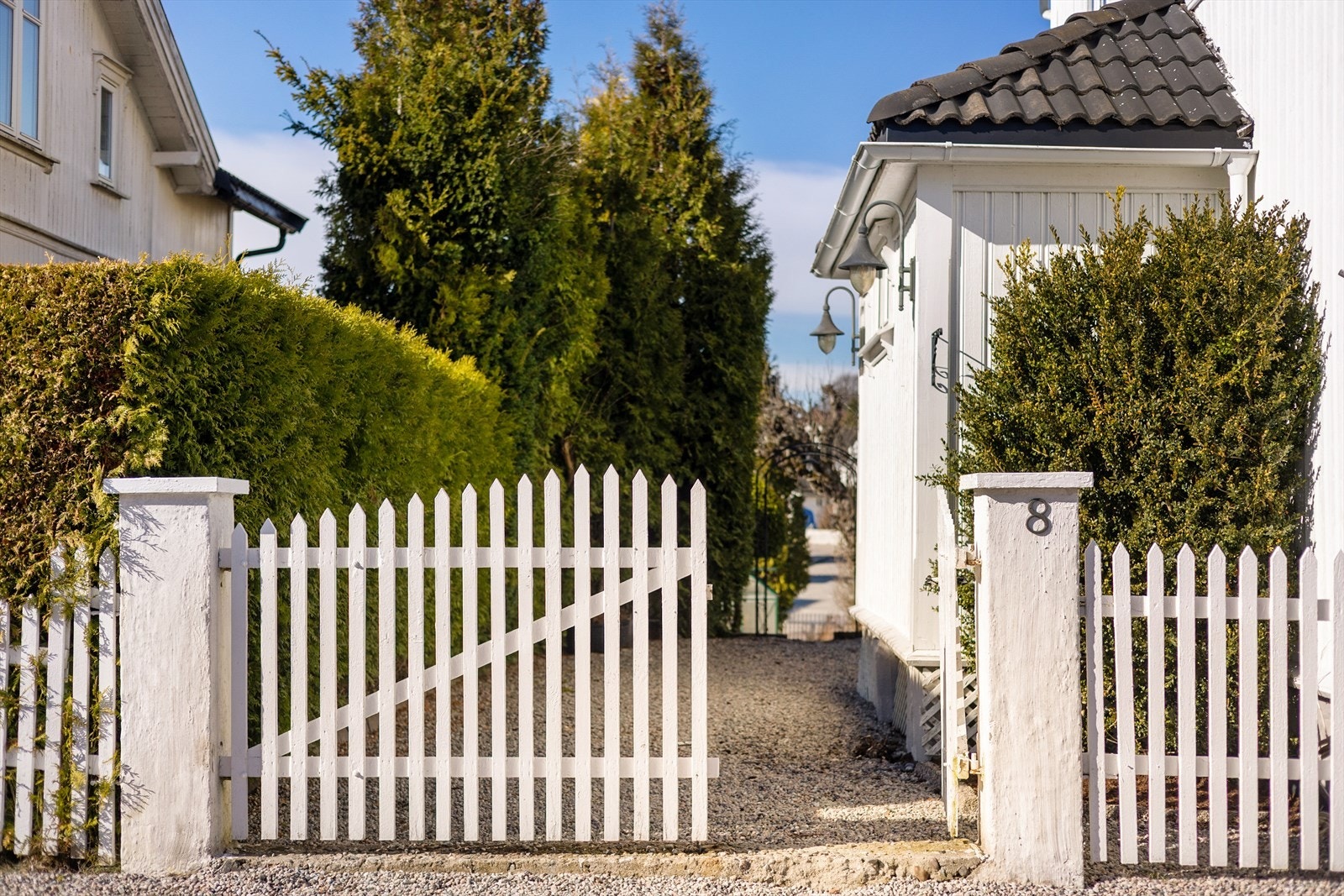 Fra gårdsplassen er det port inn til et vakkert uteområde, pent opparbeidet med trær, busker, blomster, gressplen, steinlagte gangstier og diverse beplantning. Galleribilde