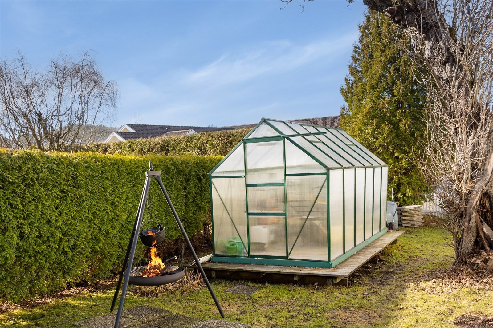 Et drivhus understreker idyllen, og hagen rammes fint inn av en hekk og et hvitmalt stakittgjerde. Galleribilde