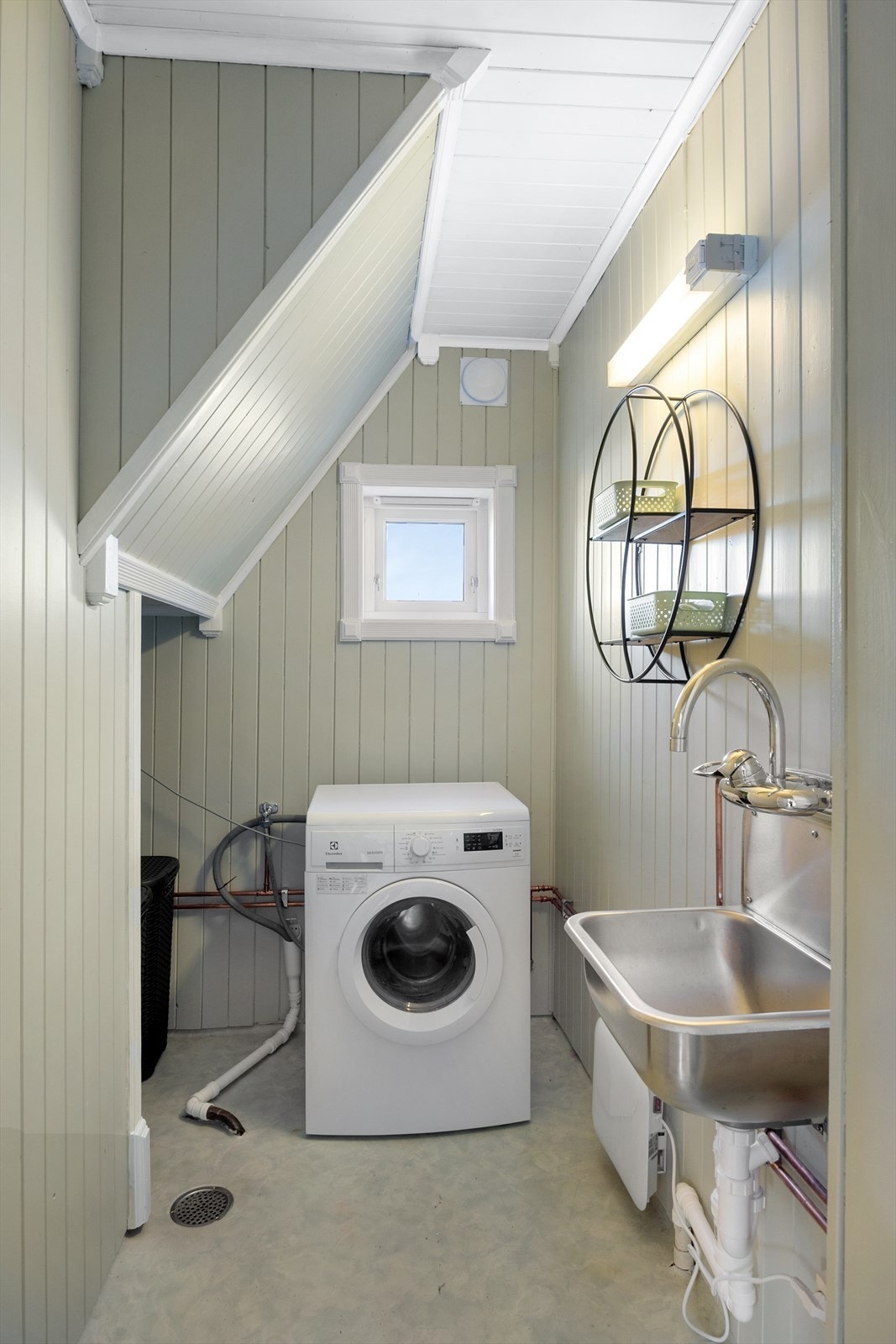 Vaskerommet har gulvbelegg, utslagsvask og opplegg for vaskemaskin. Galleribilde