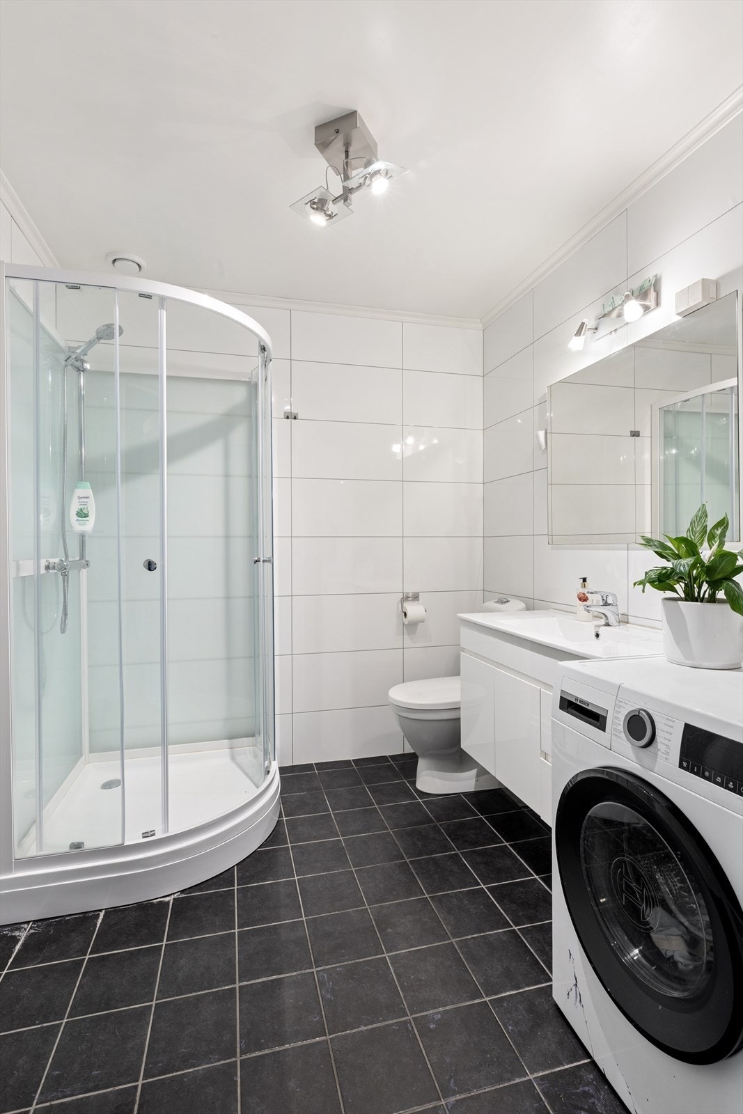 Badet i utleiedelen er flislagt og har dusjkabinett, toalett og opplegg for vaskemaskin. Galleribilde