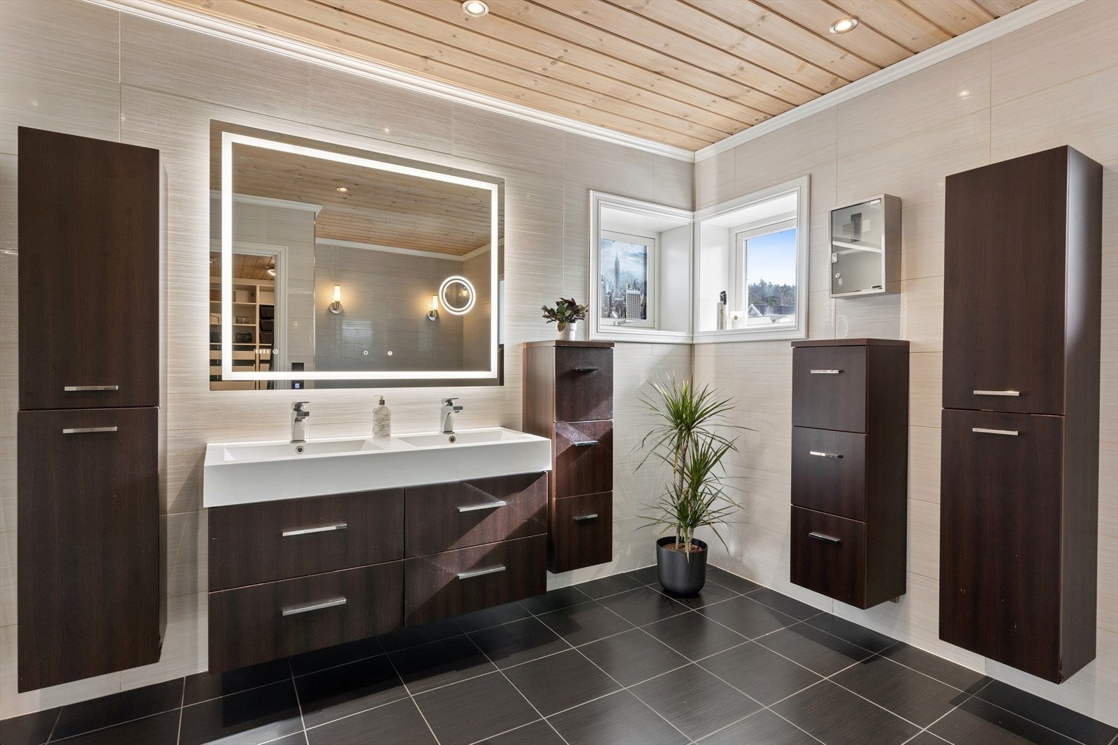 Hovedbadet er utstyrt med baderomsinnredning med dobbel servant, speil med integrert belysning, varmefelt og høyttaler. Rikelig med oppbevaring i vegghengte skap. Galleribilde