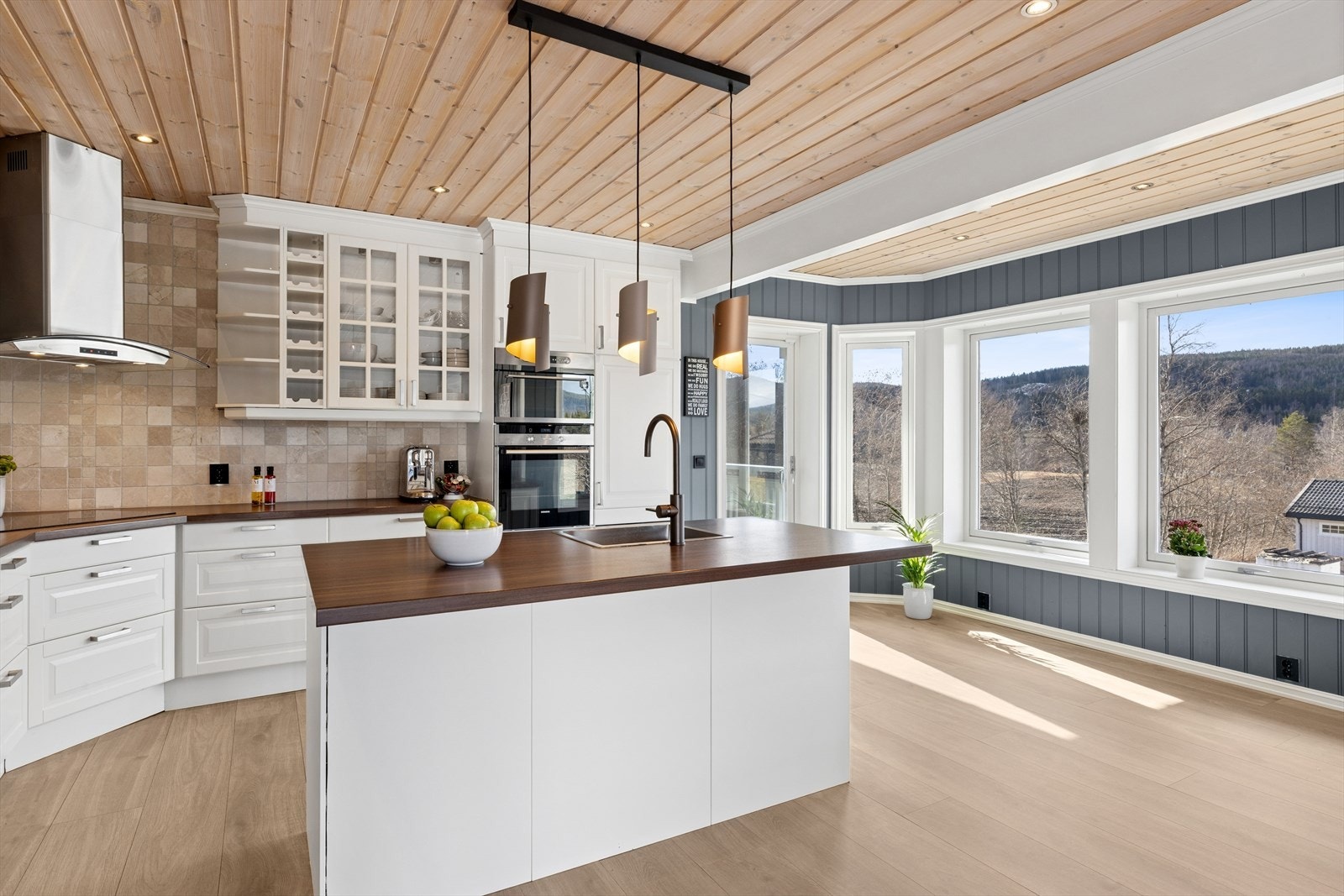 Kjøkkenet byr på en praktisk kjøkkenøy og en innredning med profilerte fronter kombinert med en laminatbenkeplate. Det er også montert en stilren Tapwell-kran. Galleribilde