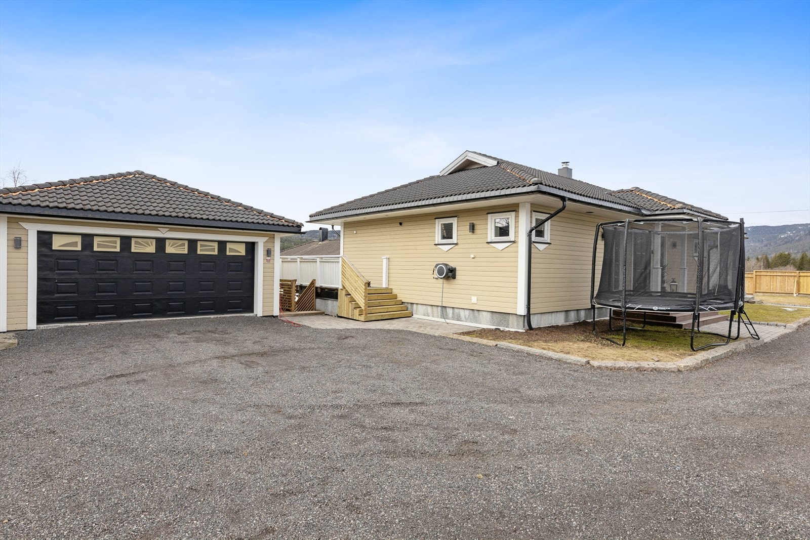 Den romslige gårdsplassen gir gode parkeringsmuligheter foran den doble garasjen. Det er installert smarte elbilladere fra Zaptec - én dedikert til hoveddelen og én til utleiedelen Galleribilde