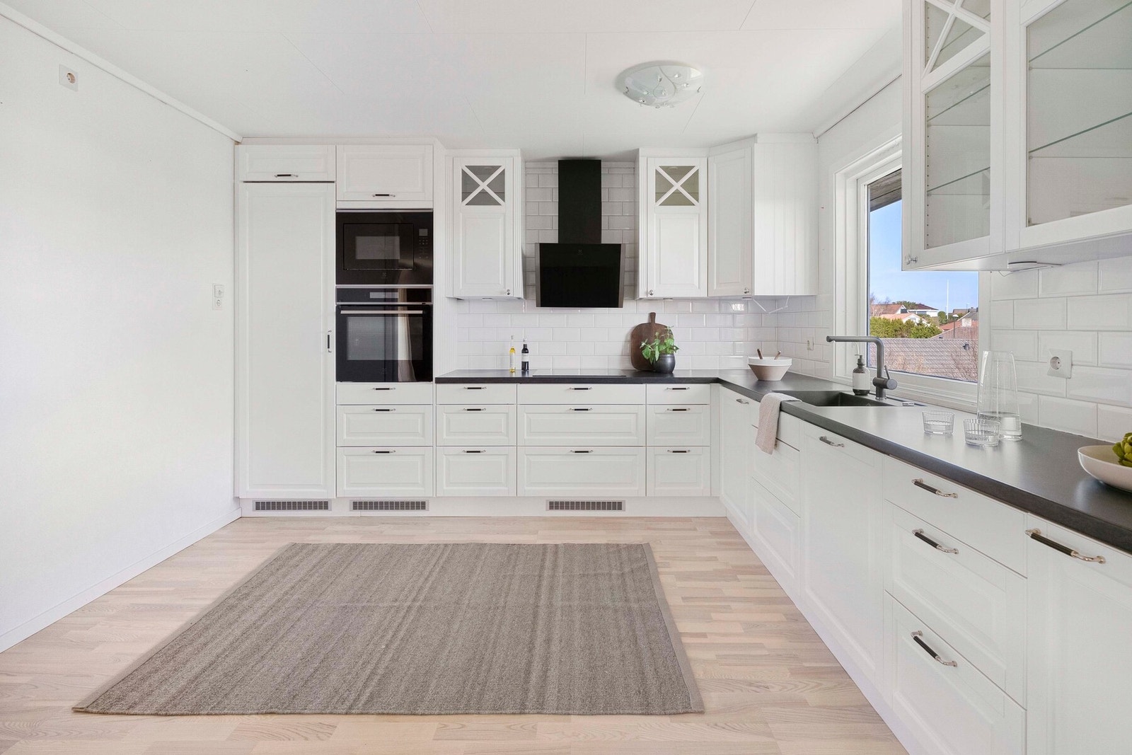 Flislagt backsplash gjør rengjøringen enkel, og ventilator med avtrekk ut av boligen sørger for et godt inneklima. Galleribilde