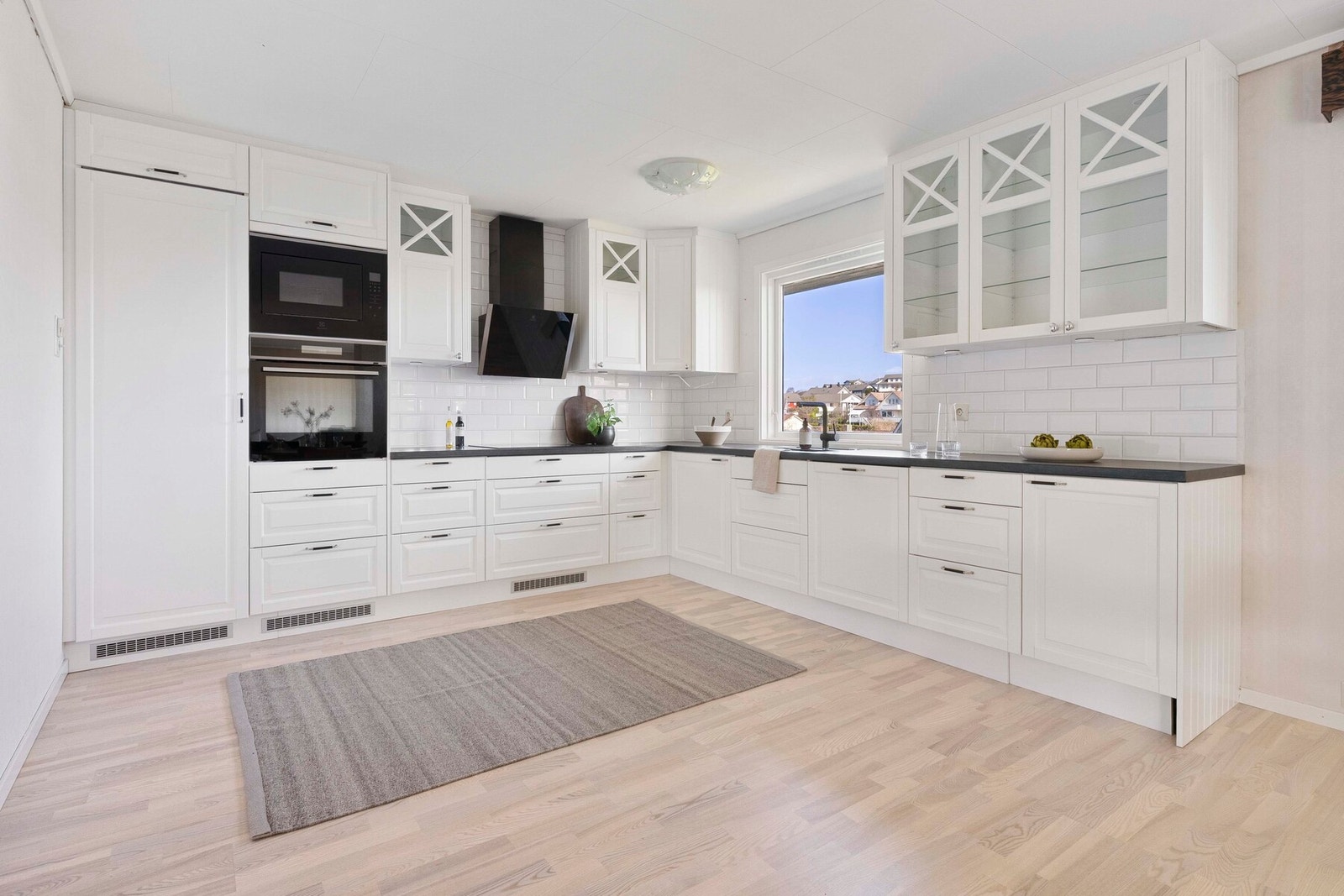 Kjøkkenet i hoveddelen har en funksjonell og tidløs utforming med hvite, profilerte fronter fra Epoq og en praktisk laminat benkeplate. Galleribilde