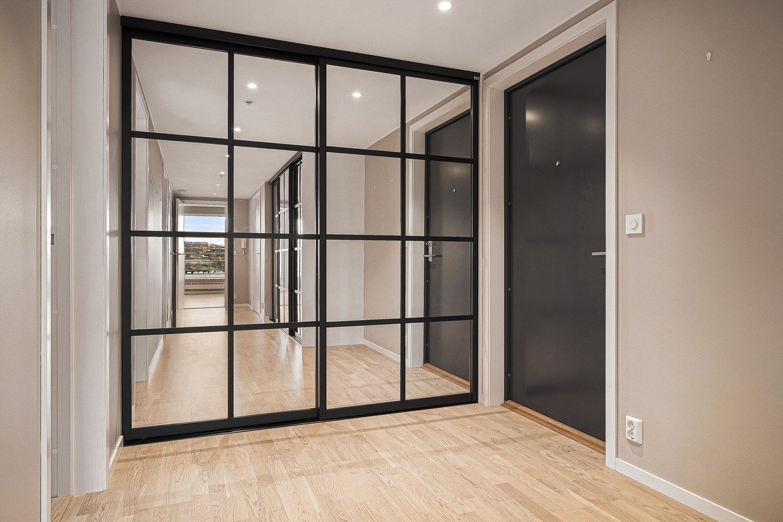 Man ønskes velkommen av en romslig og trivelig gang målt til 15,7m². Her er det skyvedørsgarderobe med speilfronter og god plass til oppbevaring av yttertøy og sko. Galleribilde