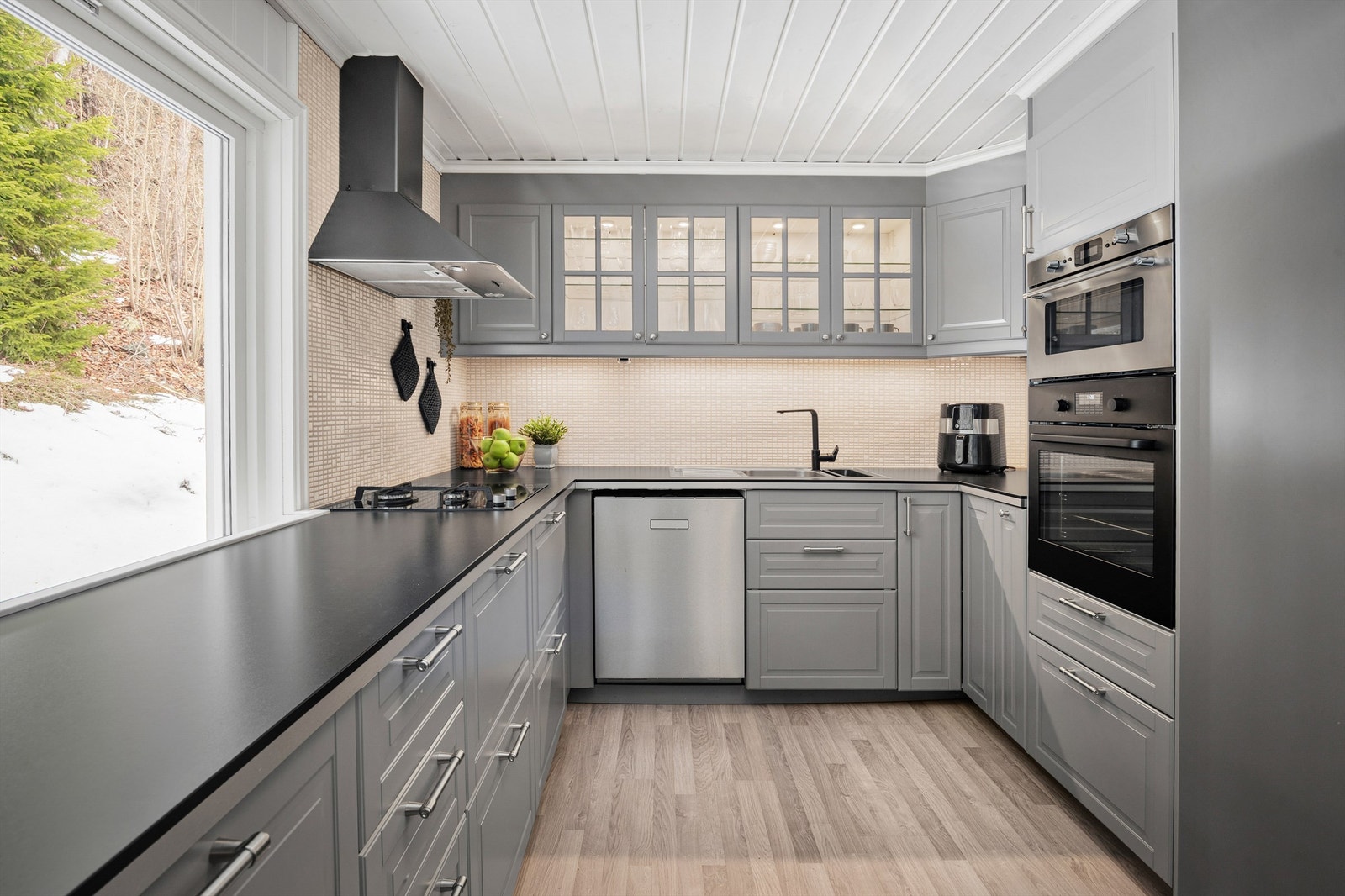 Pent IKEA kjøkken med innredning med profilerte fronter. Benkeplaten er av laminat. Integrert gassbluss, induksjonstopp, micro og stekeovn. Plass til oppvaskmaskin kjøle/fryseskap. Galleribilde