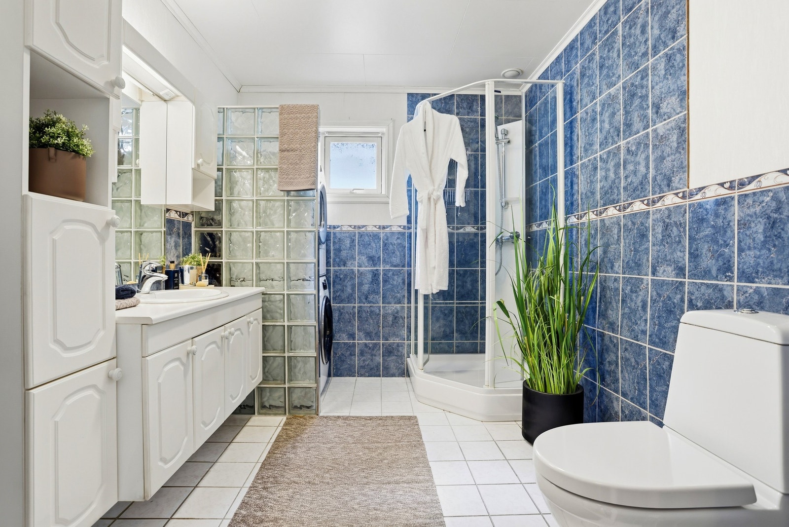 Badet er fra byggeår. Utstyrt med dusjkabinett, innredning med skap, toalett og opplegg for vaskemaskin. Galleribilde