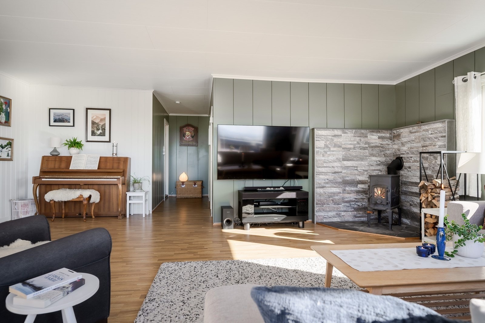 I hjørnet av stuen er det en koselig peisovn som både gir god varme og bidrar til ekstra hygge på kaldere høst- og vinterdager. Galleribilde