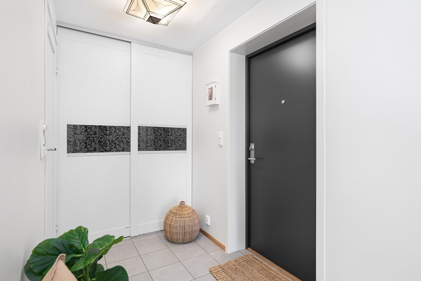 Romslig entré med klesoppbevaring i skyvedørsgarderobe og varme i gulv. Galleribilde