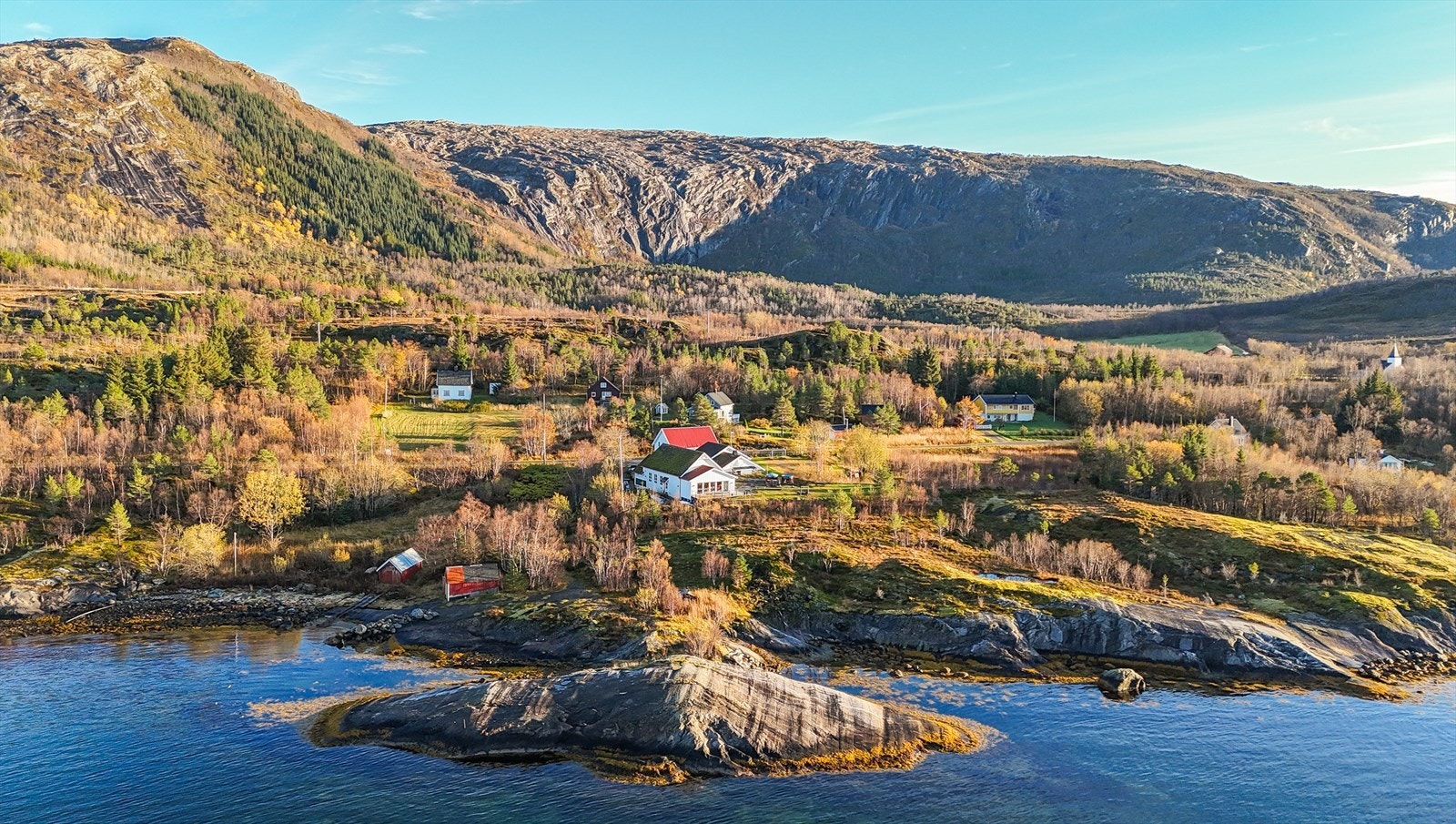 Eiendommen ligger i naturskjønne omgivelser ved Sørfjorden i Rødøy kommune, med en spektakulær og vidstrakt utsikt over fjord, øyer og det åpne havet langs Helgelandskysten. Galleribilde