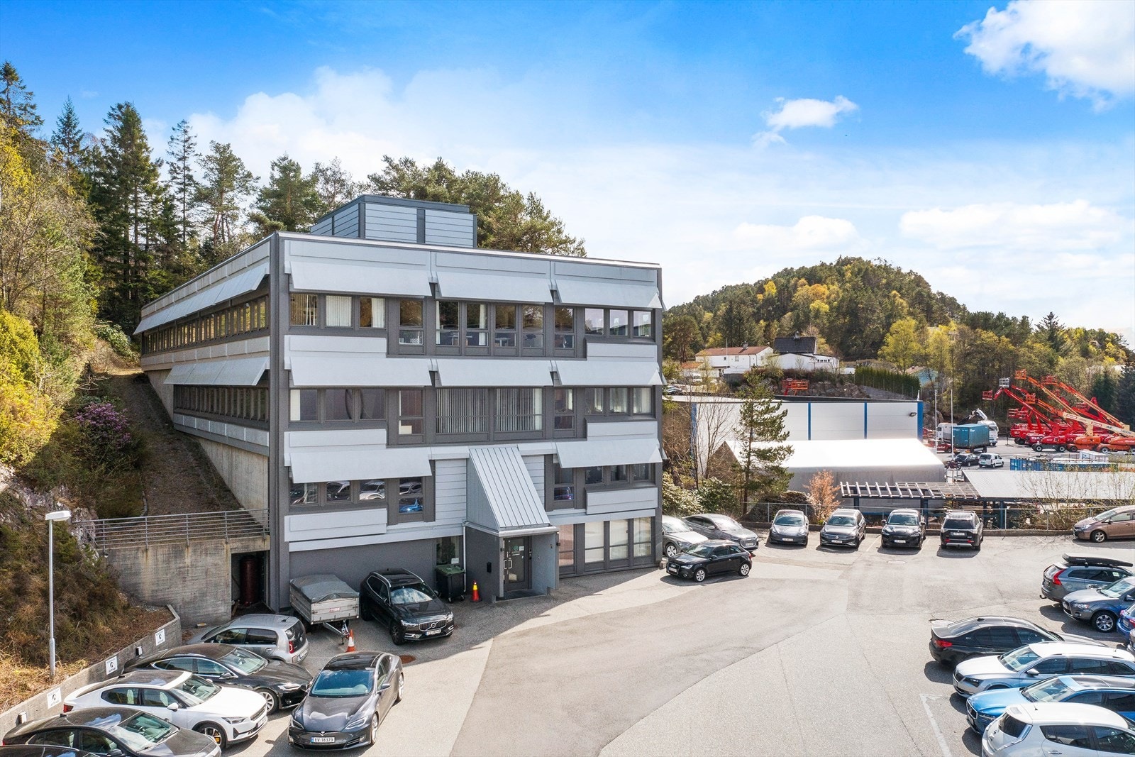Kontorlokalene ligger i kontorbygg tvers over plassen fra lager.