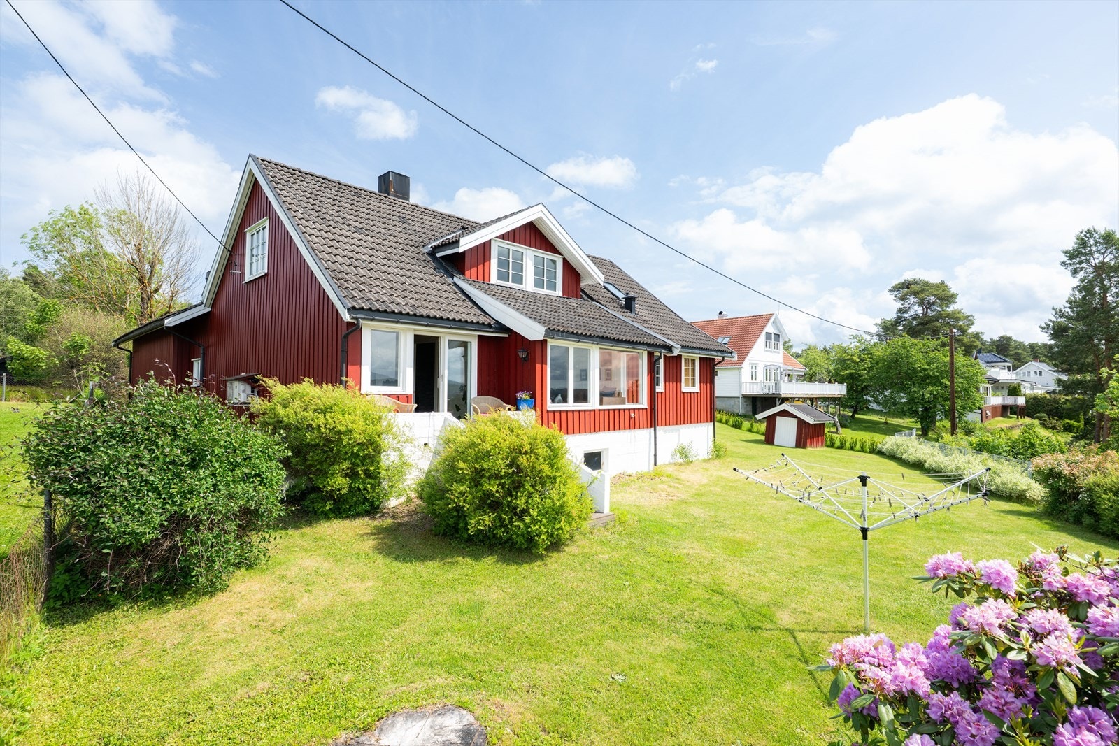 Fra stua er det utgang til en liten veranda med fin plass til et lite møblement. Herfra er det trapp videre ned til hagedelen og den flotte terrassen som ligger nydelig til ute på pynten. Galleribilde