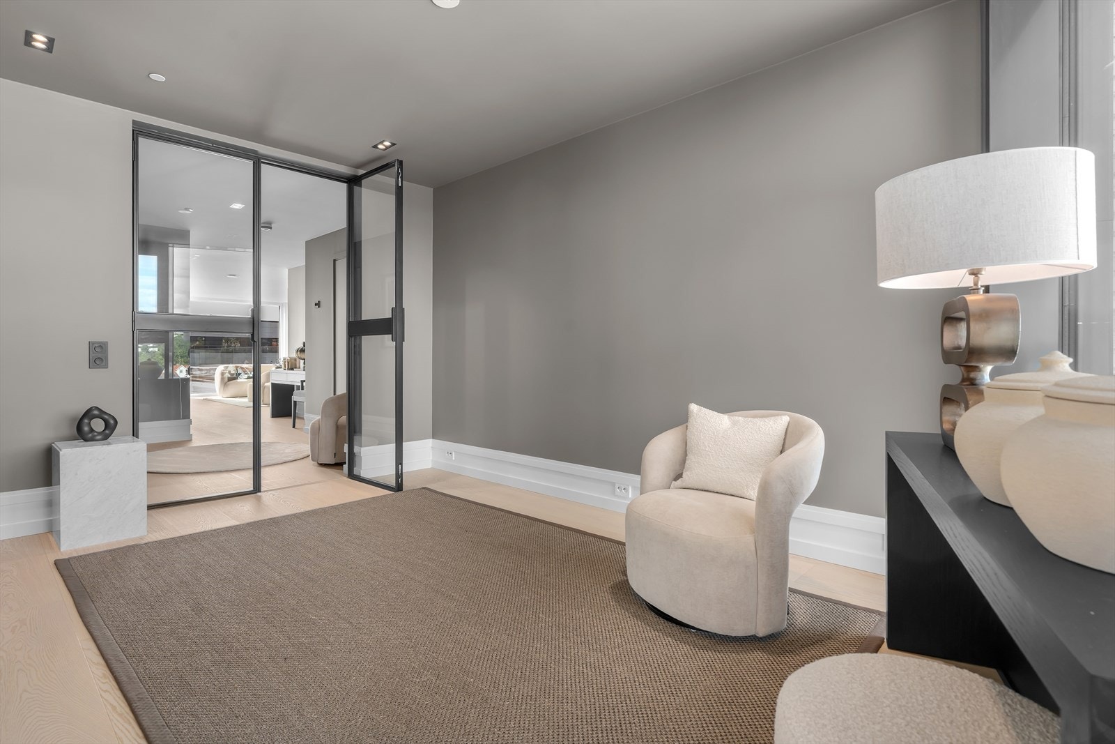 Lys, luftig og romslig entré med glass dør inn til leiligheten. Galleribilde