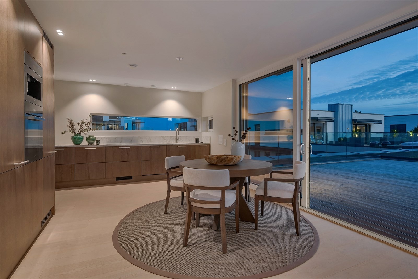 Stor skyvedør ut fra kjøkkenet til en imponerende takterrasse på hele 80 kvm - med rikelig spiseplass og komfortable sitteområder. Galleribilde