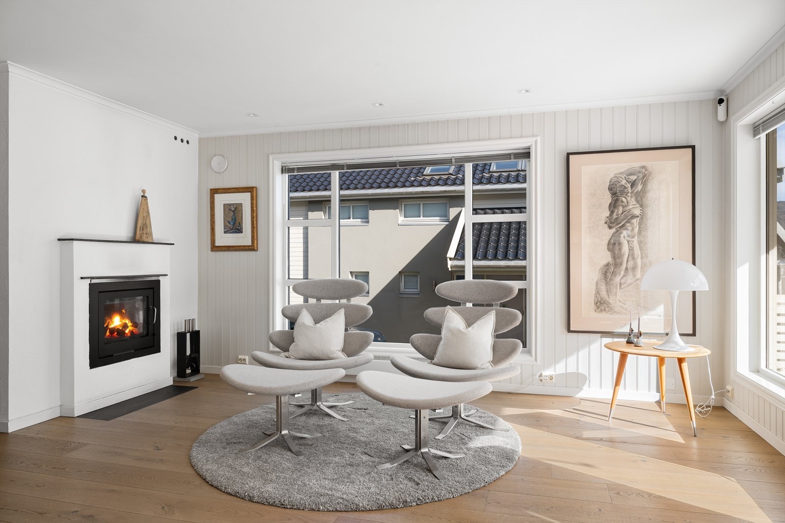 Innbydende stue med peis og store vindusflater som slipper inn rikelig med naturlig lys. Galleribilde