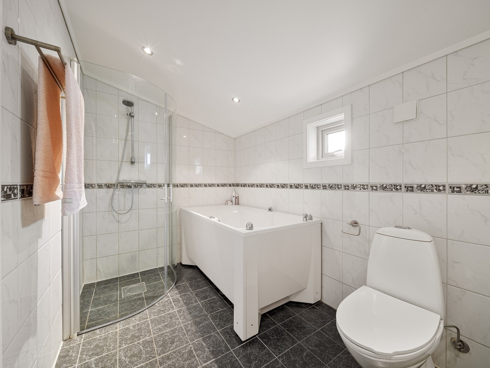 Badet er innredet med boblebadekar, dusjdører, servant, møbler og wc, og har behagelig elektrisk gulvvarme. Galleribilde