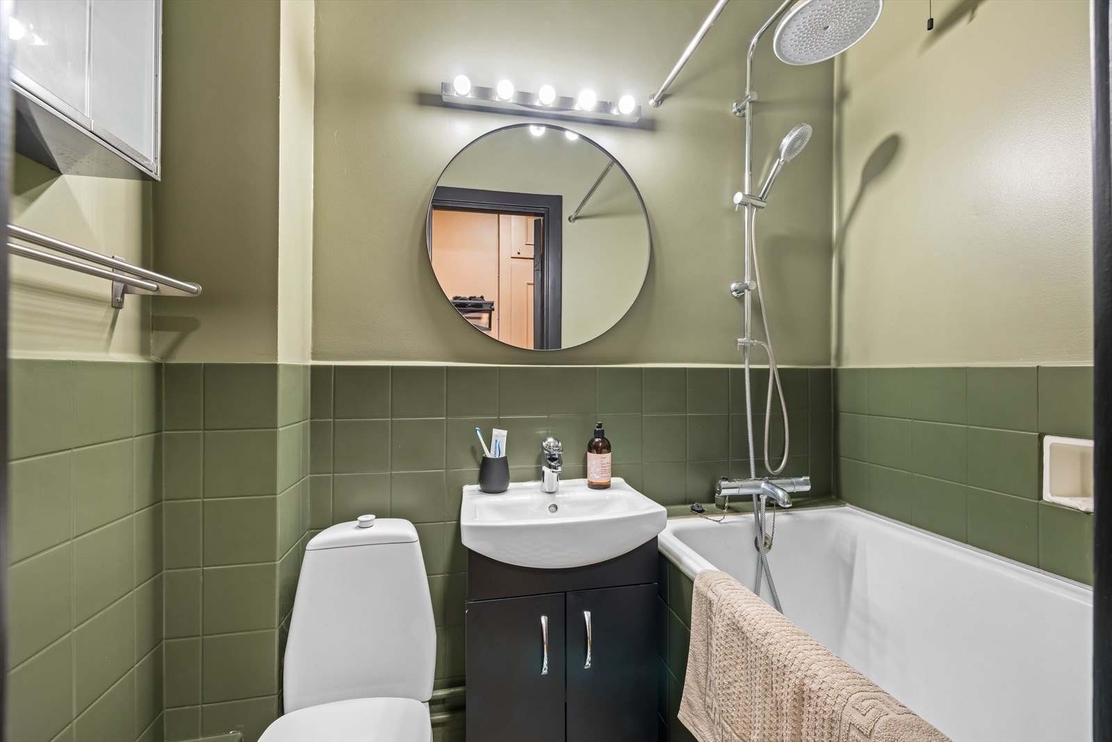 Badet er delvis flislagt og innredet med servant med underskap, speil og toalett. Galleribilde