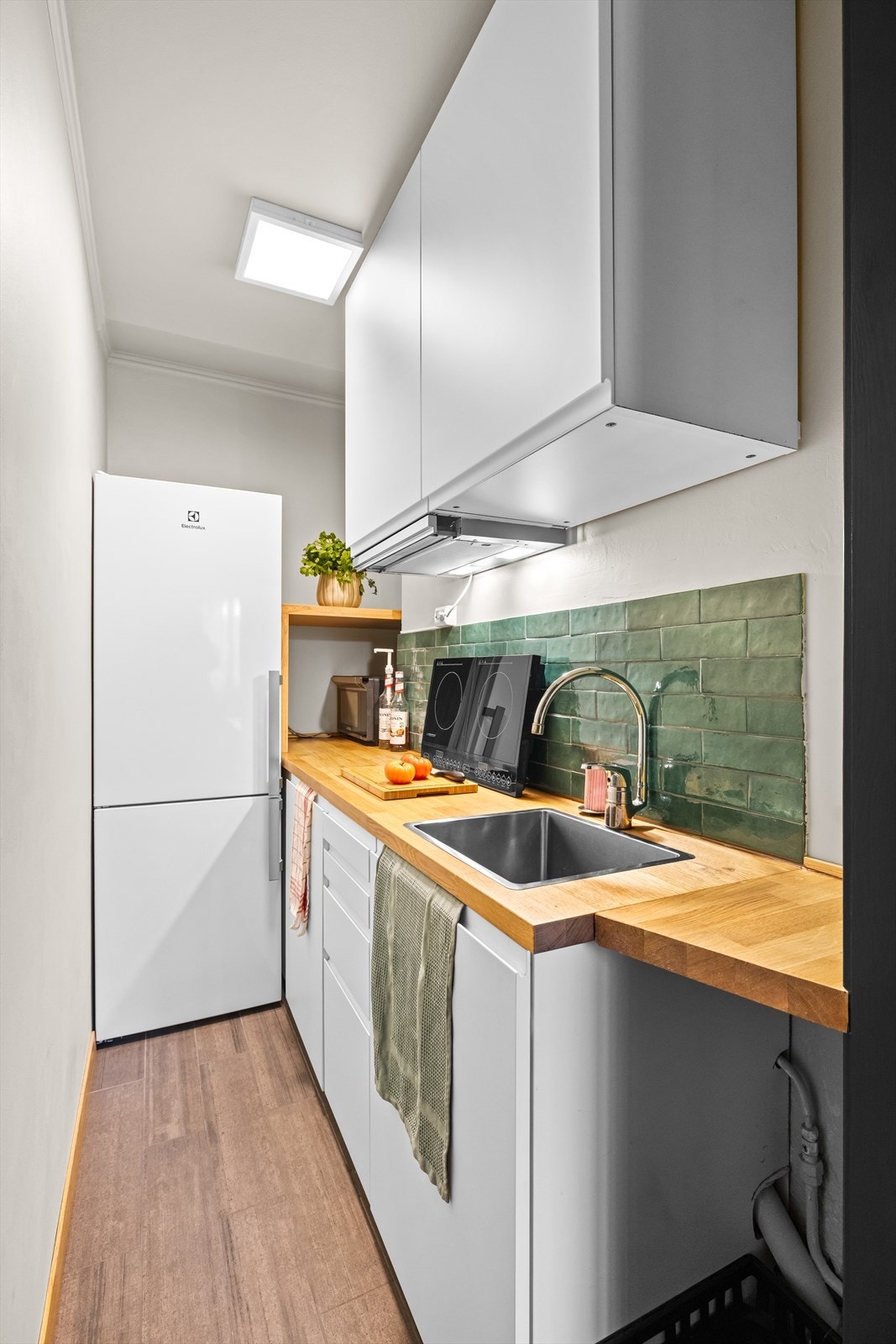 Kjøkken fra 2024 med glatte folierte fronter og laminat benkeplate. Galleribilde