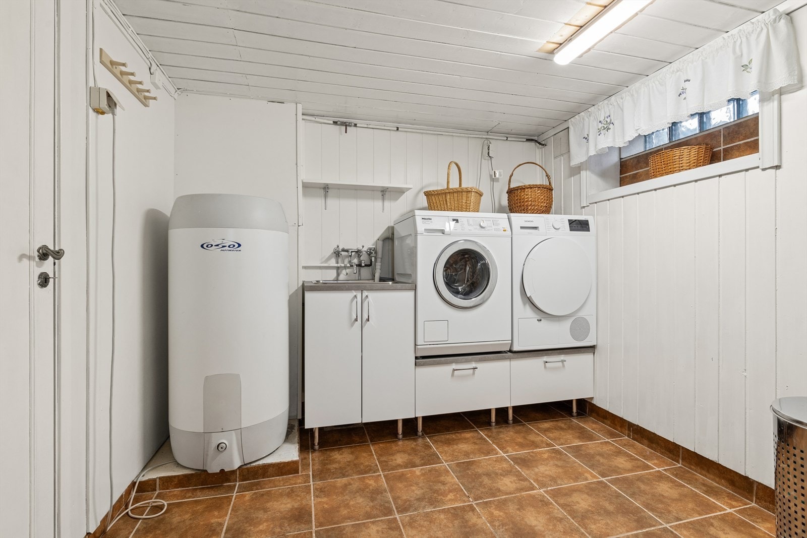 Praktisk vaskerom med opplegg for vaskemaskin. Galleribilde