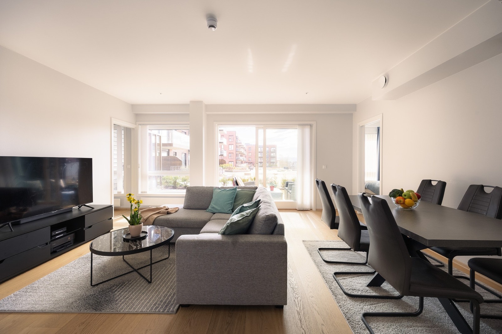 Stuen fremstår som lys og luftig, med store vindusflater som slipper inn rikelig med naturlig lys gjennom dagen. Galleribilde