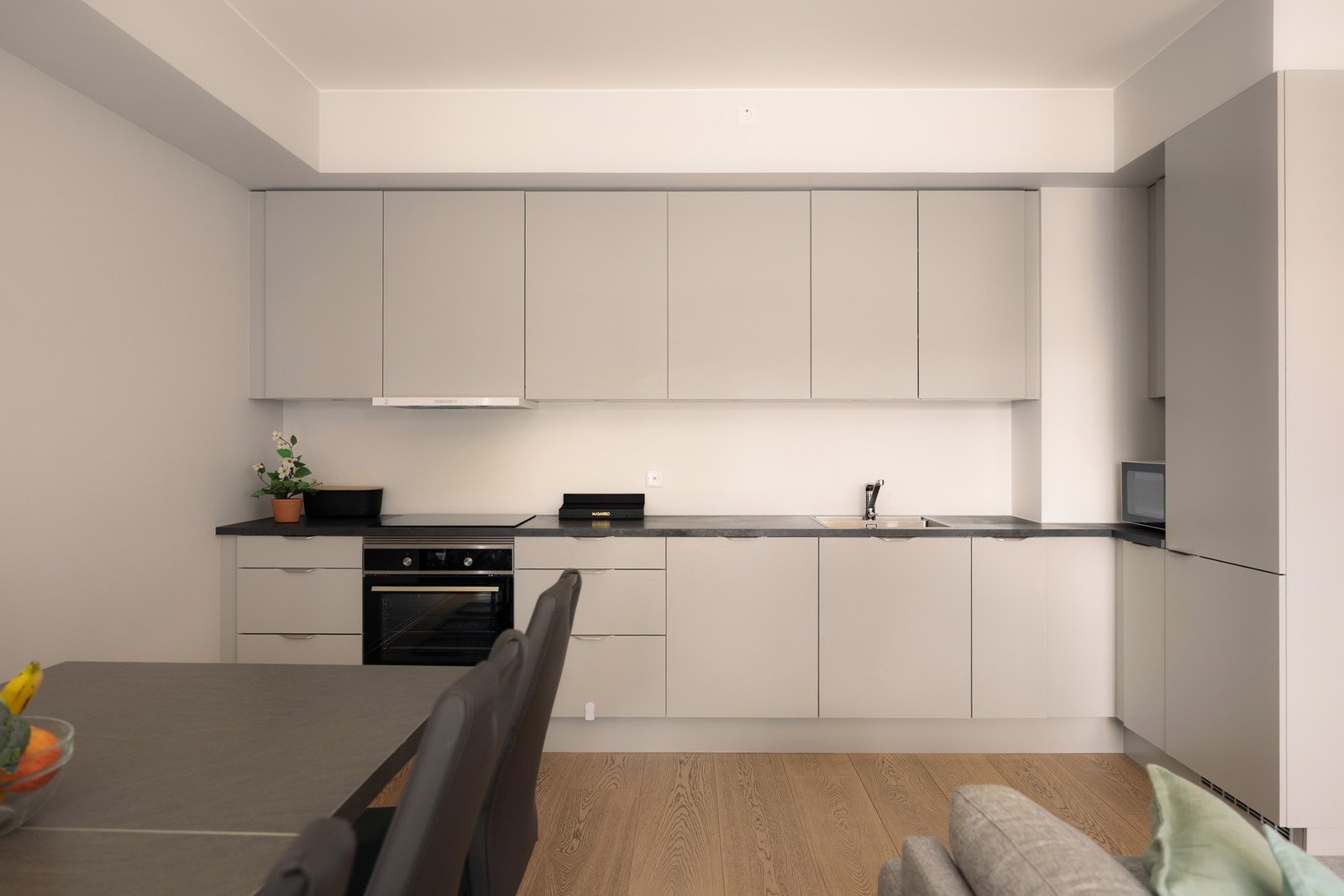 Kjøkkeninnredningen er fra byggeåret 2022 og har glatte fronter som gir et moderne uttrykk, kombinert med en slitesterk benkeplate i laminat og nedfelt vask med armatur. Galleribilde