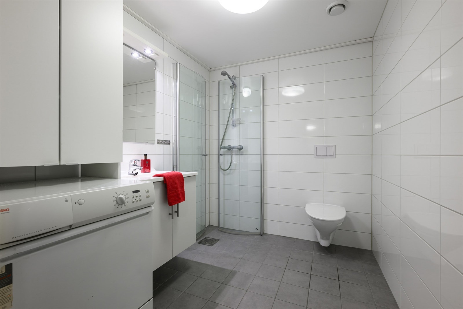 Helfliset bad i 1.etg. med vegghengt toalett, dusjhjørne og opplegg for vaskemaskin. Galleribilde