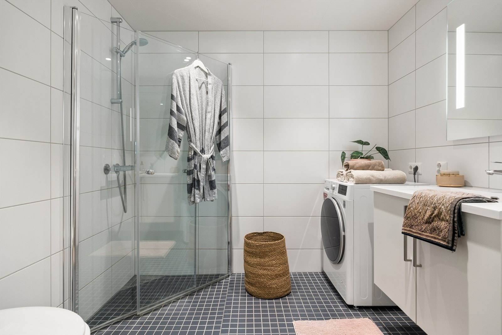 Badet er utstyrt med vegghengt toalett og et praktisk dusjhjørne med innfellbare glassdører. Galleribilde