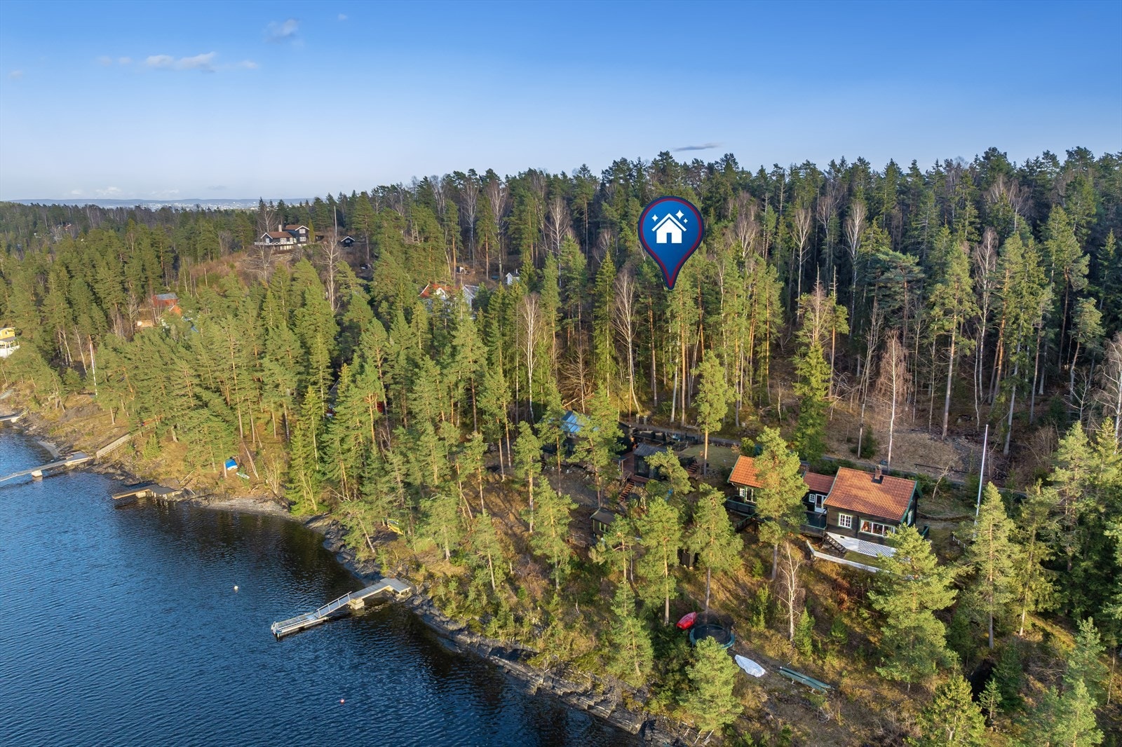 Oversikt over eiendommen og dens plassering i det grønne landskapet på Brønnøya. Galleribilde