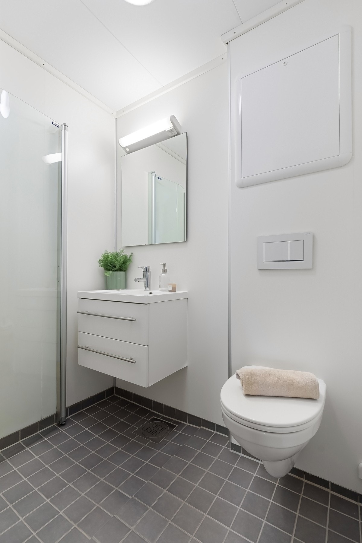 Badet har lys innredning og en fin kontrast med det mørke gulvet. Det medfølger egen kjellerbod til vask/tørk som er seksjonert til leiligheten. Galleribilde
