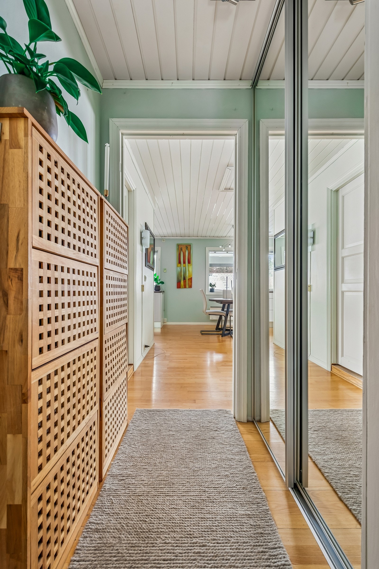 Innbydende entré med god lagringsplass i skyvedørsgarderobe med speilfronter. Galleribilde