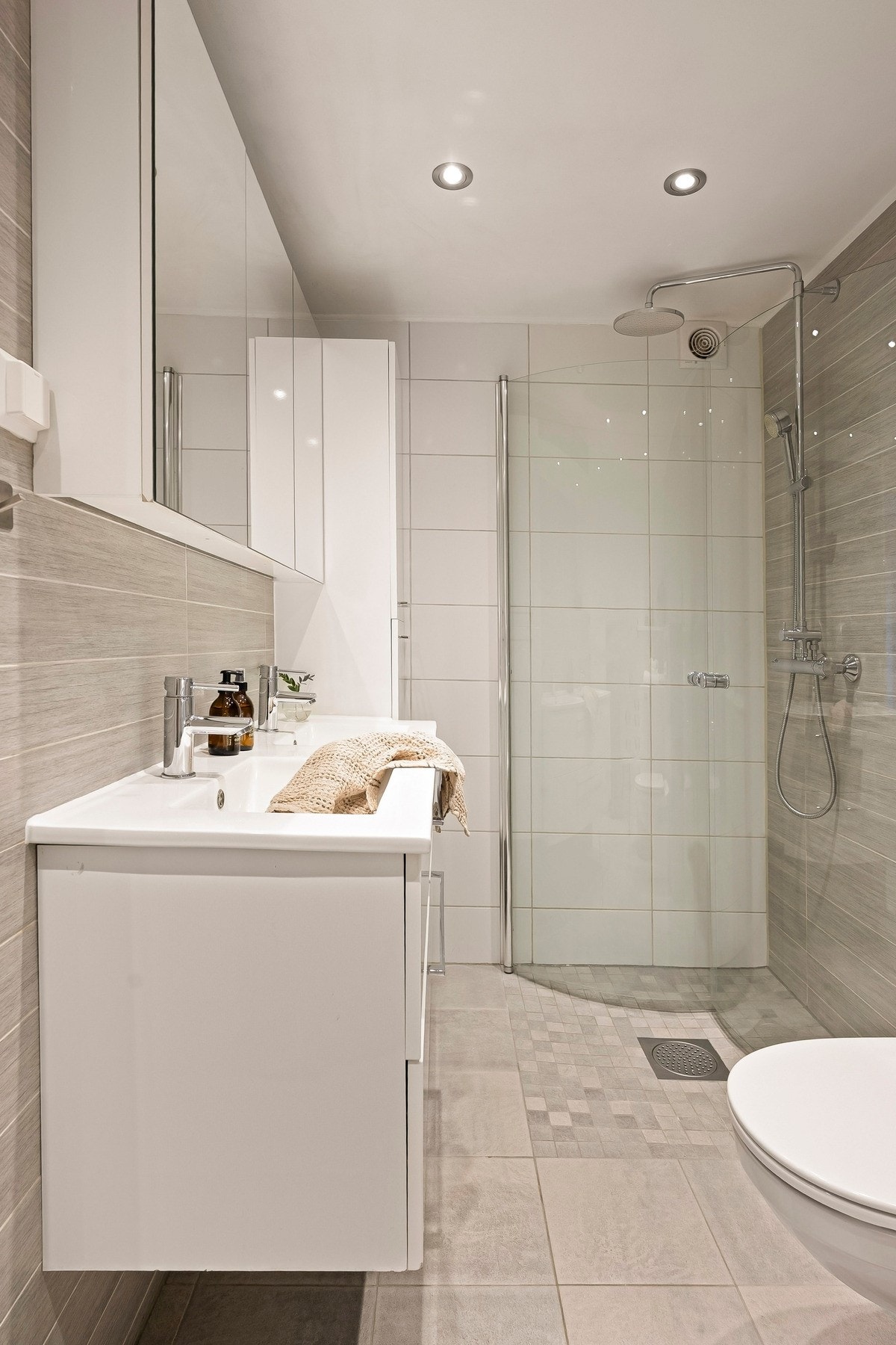 Badet har vegghengt servantinnredning med skuffer og ovenpåliggende servant, samt speilskap på vegg over servant. Galleribilde