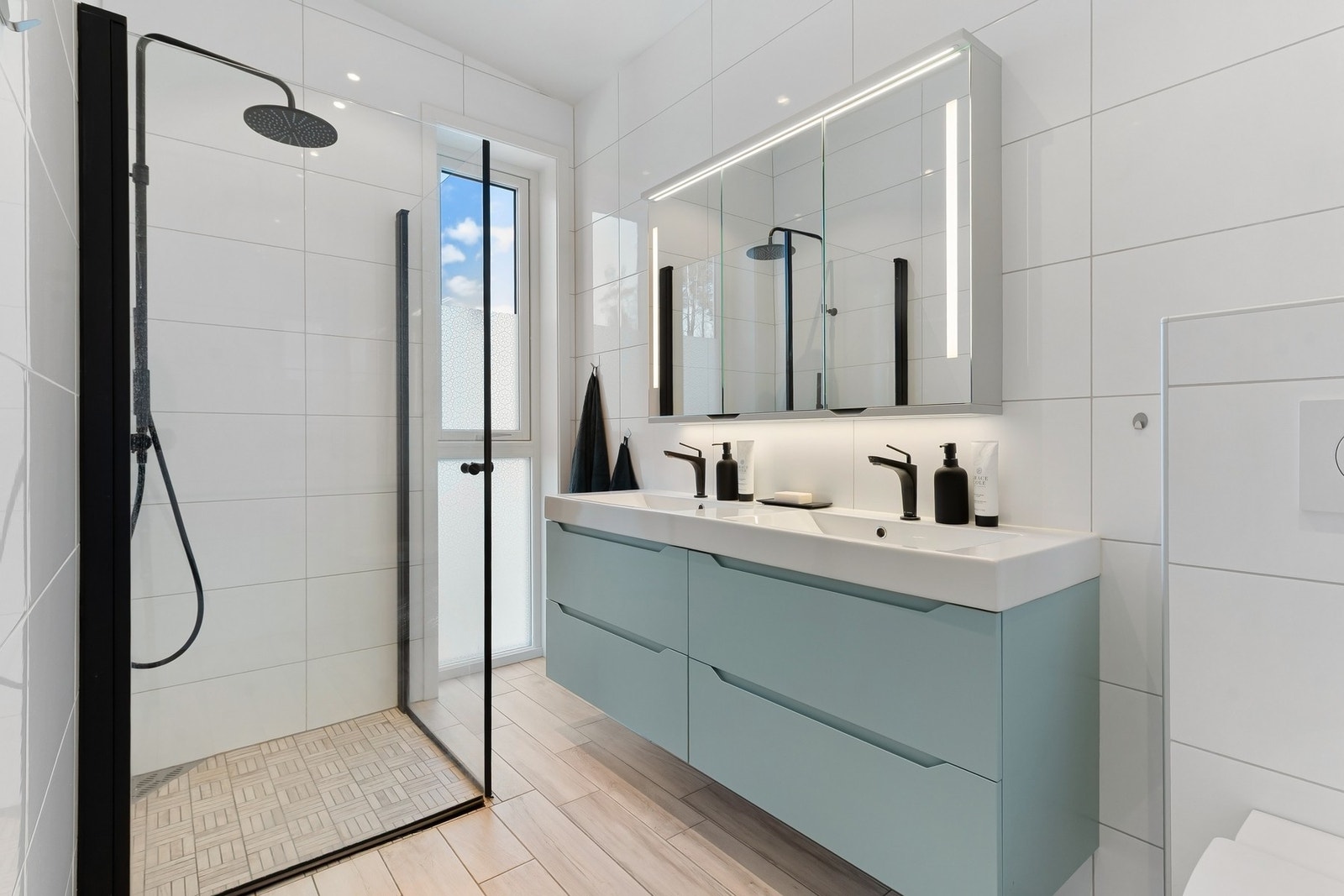 Badet i 2. etasje har en flott og moderne innredning fra Linn bad med 2 nedfelte servanter, speilskap, dusjhjørne med innsvingbare glassdører og vegghengt WC Galleribilde