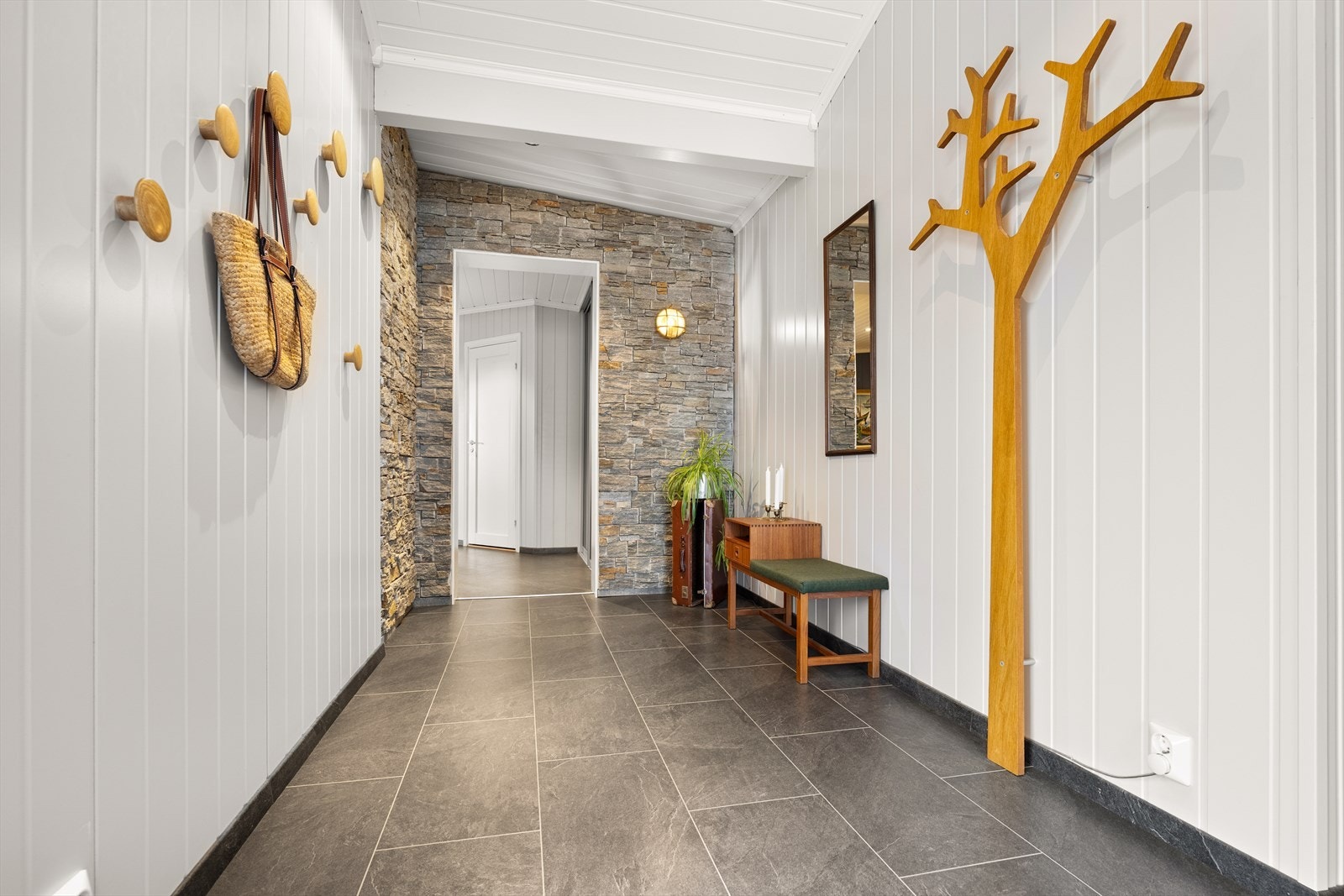 Den gjennomgående takhøyden, kombinert med lyse overflater og innfelte downlights, gir et åpent og elegant uttrykk som forsterker romfølelsen og skaper en imponerende entré. Galleribilde