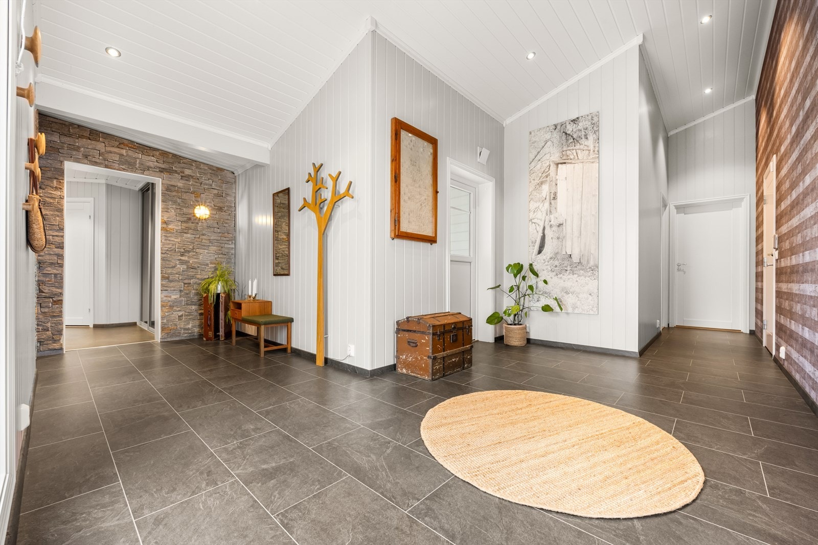 Innbydende hall med god plass til oppbevaring av klær og sko. Hallen skaper et fint førsteinntrykk av boligen med sine gjennomførte detaljer. Galleribilde