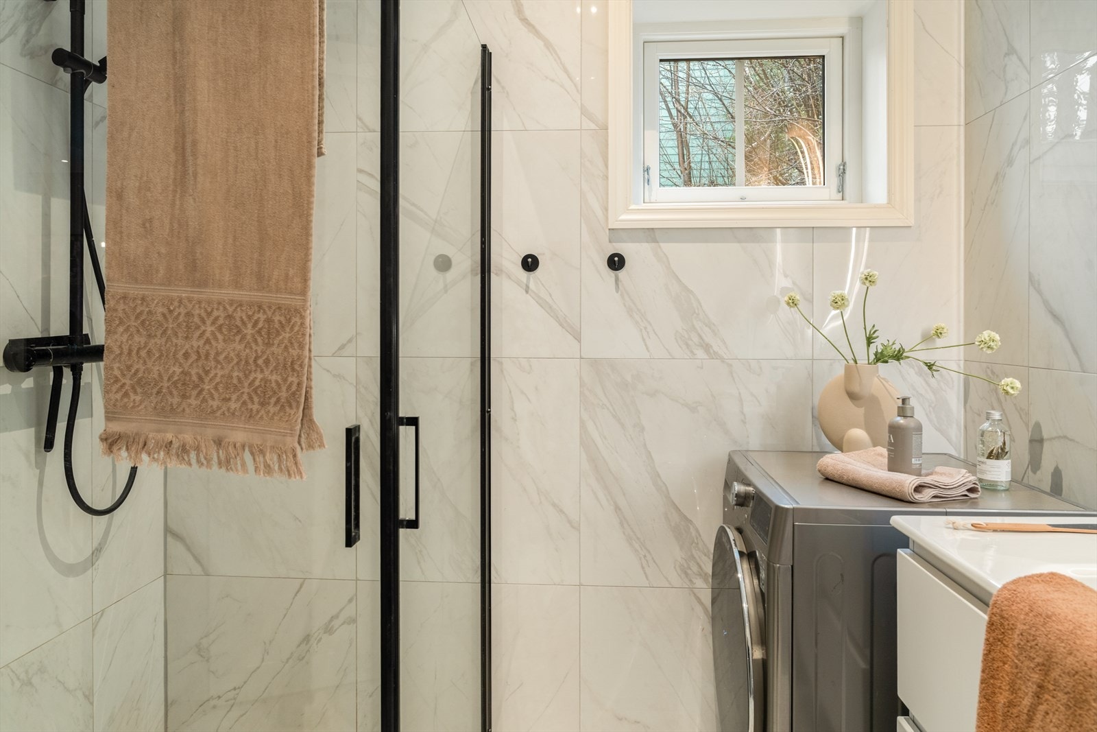 Innredningen består av nedfelt servant, vegghengt toalett, dusjvegger og opplegg for vaskemaskin. Galleribilde