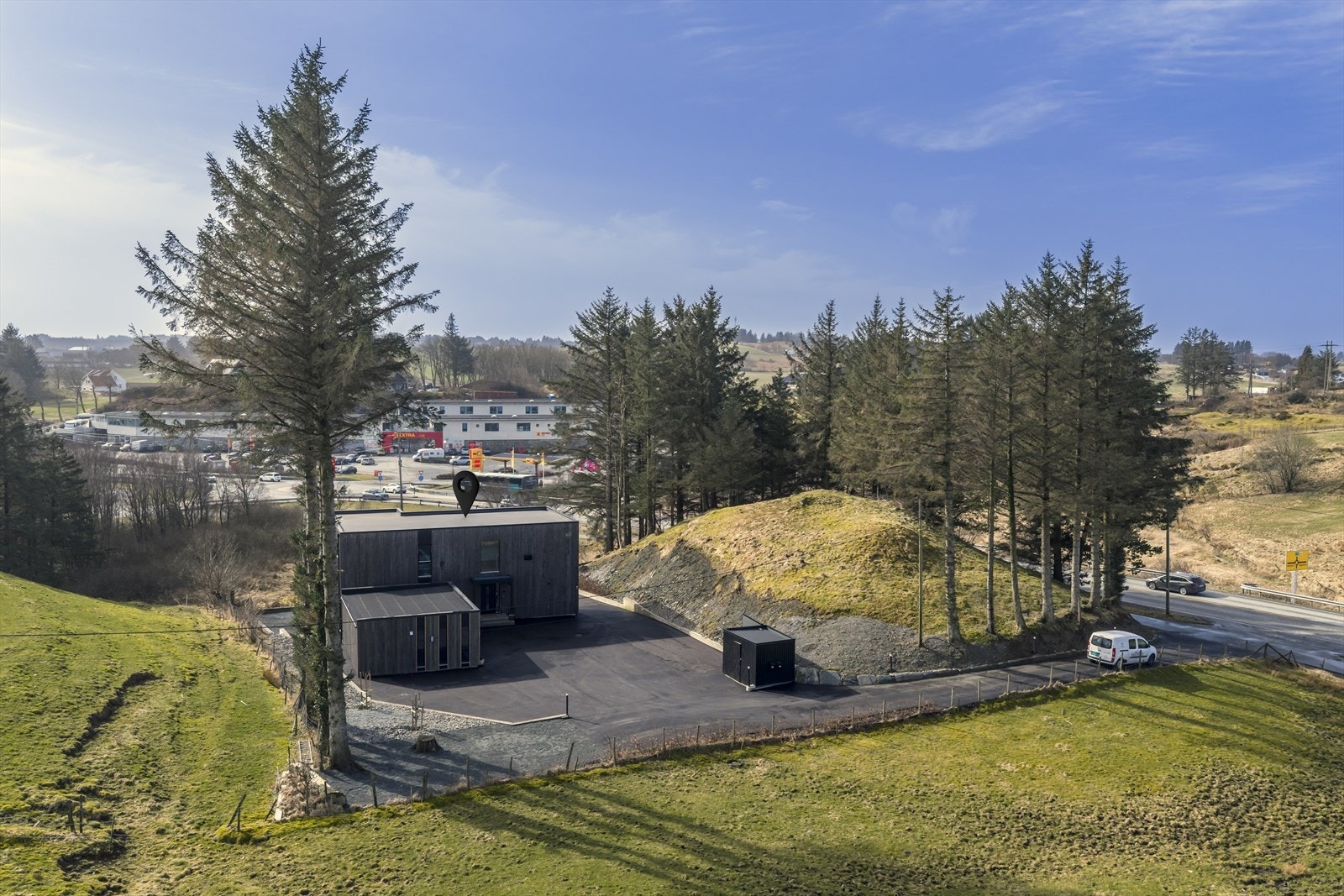 Tomten er pent opparbeidet med asfaltert innkjørsel med belysning, asfaltert gårdstun samt noe beplantning som gir et ryddig og trivelig uteområde Galleribilde