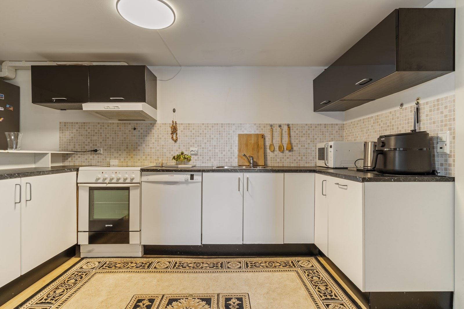 Leiligheten har et tidløst kjøkken med god skap- og benkeplass samt frittstående hvitevarer Galleribilde