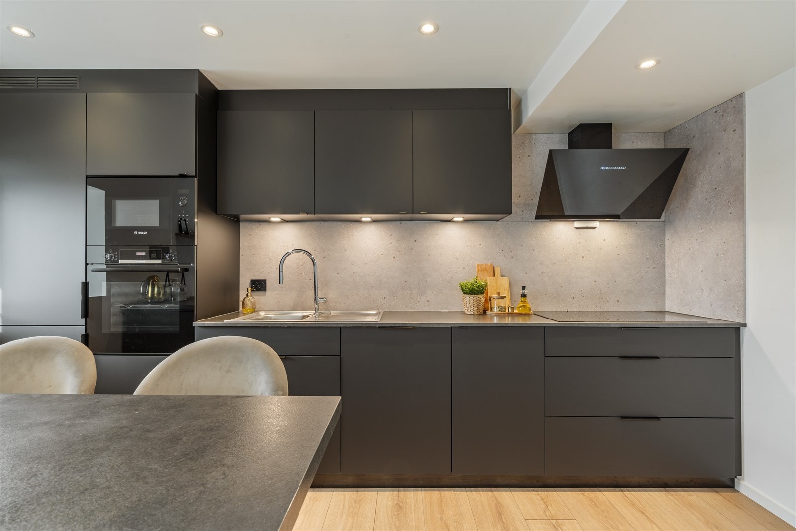 Kjøkkenet har innredning med slette fronter og laminat benkeplate Galleribilde