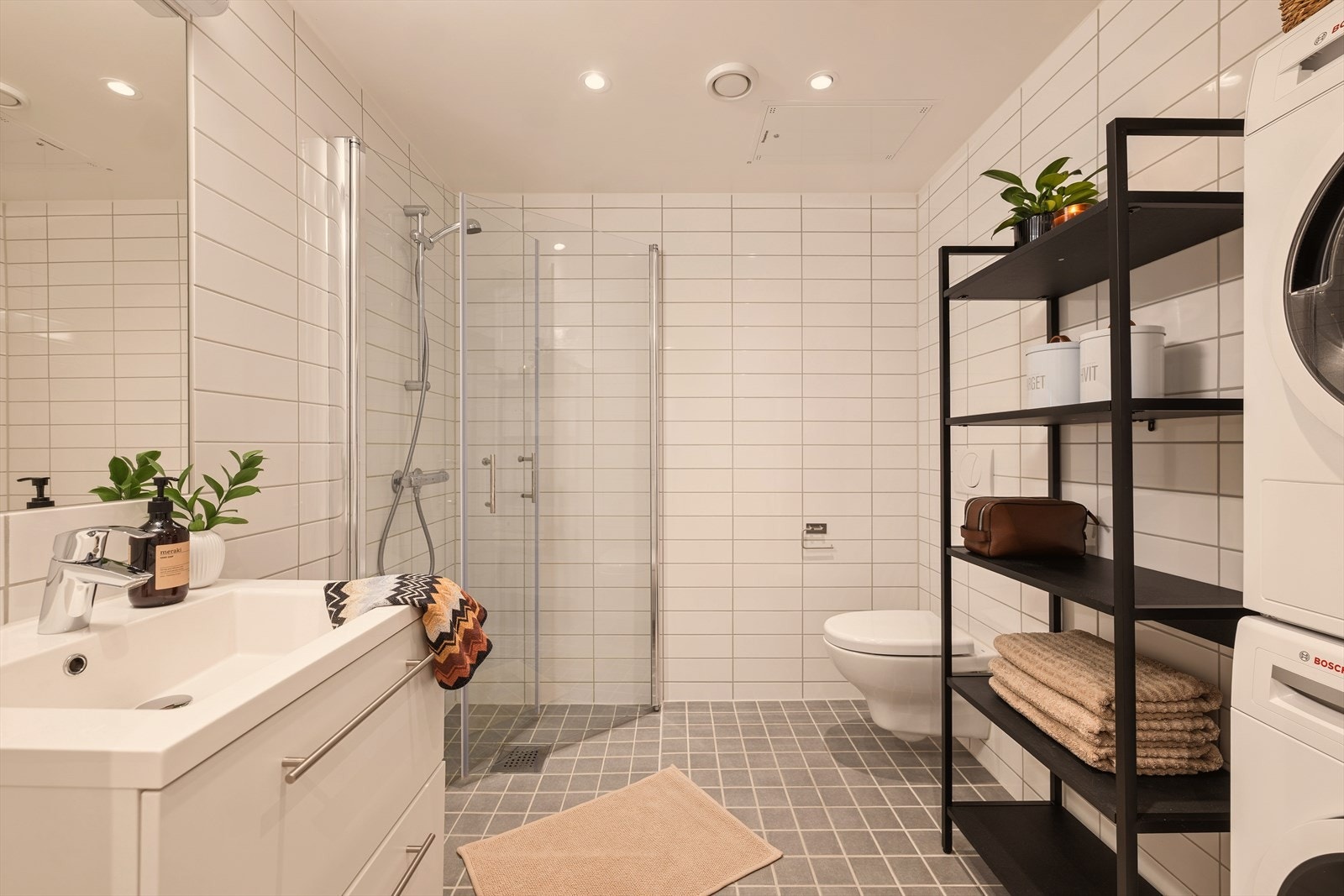 Romslig flislagt bad med gulvvarme og vaskesøyle. Galleribilde