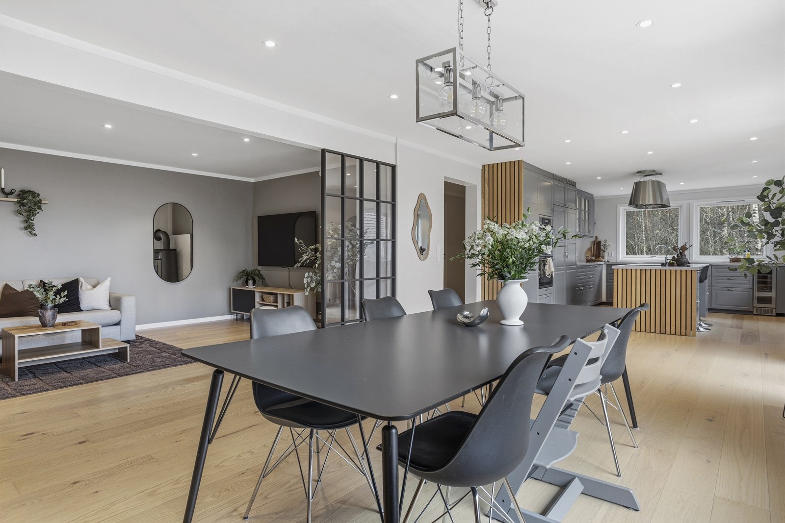 Den åpne planløsningen gir en harmonisk flyt mellom oppholdsrommene, samtidig som møblering og lysbruk skaper en naturlig inndeling av soner for både avslapning, måltider og sosialt samvær. Galleribilde