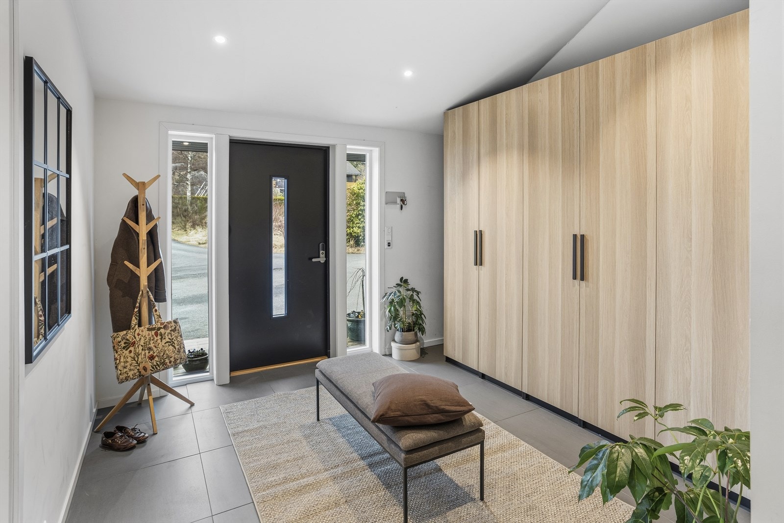 Boligen ønsker deg velkommen med en innbydende og romslig gang. Her får du store 60x60 fliser som gir et moderne uttrykk, samt svært gode oppbevaringsmuligheter for både hverdagstøy og sesongutstyr. Galleribilde