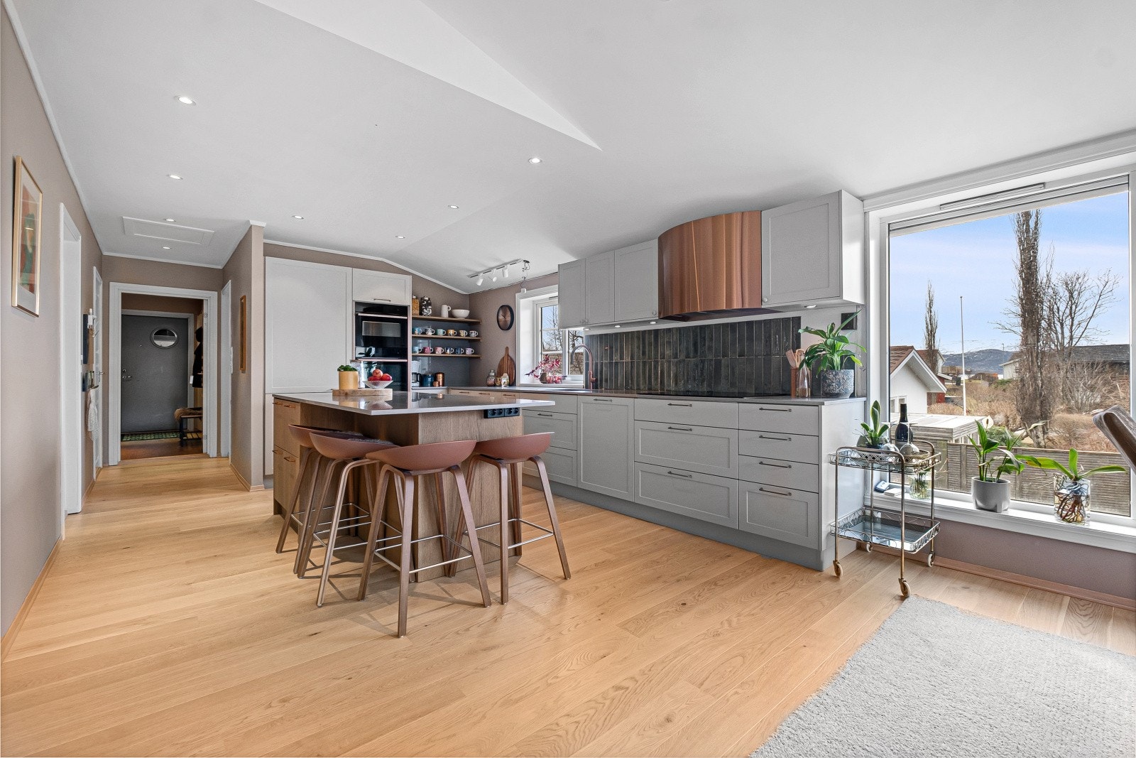 Moderne kjøkken med innredning med glatte fronter og en praktisk kjøkkenøy, benkeplaten er av stein Galleribilde