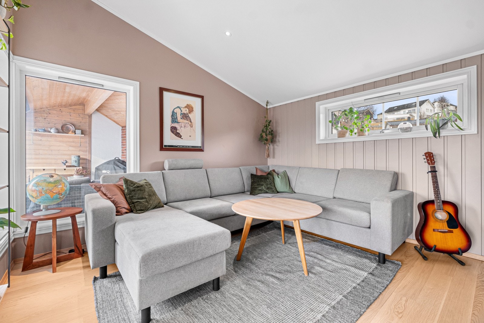 Stuen byr på fleksible og gode møbleringsmuligheter, hvor sofakroken finner sin naturlige plass i et hjørne, med et ildsted som varmer godt og plass til TV på benk eller vegghengt Galleribilde